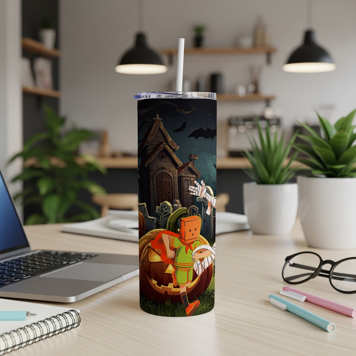 Tumbler with Halloween scene of a haunted house, graveyard, pumpkin, and costumed figures.