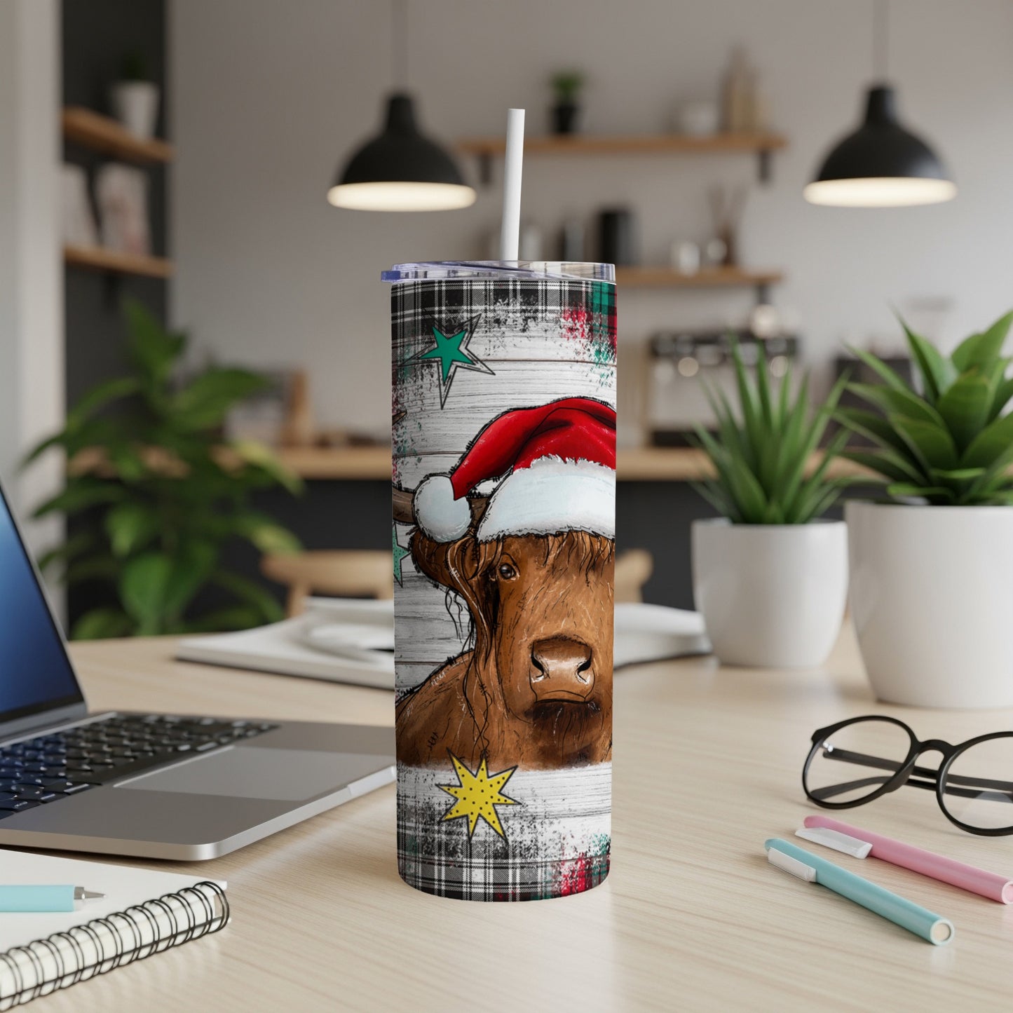 Highland cow wearing Santa hat on festive tumbler with stars and plaid.