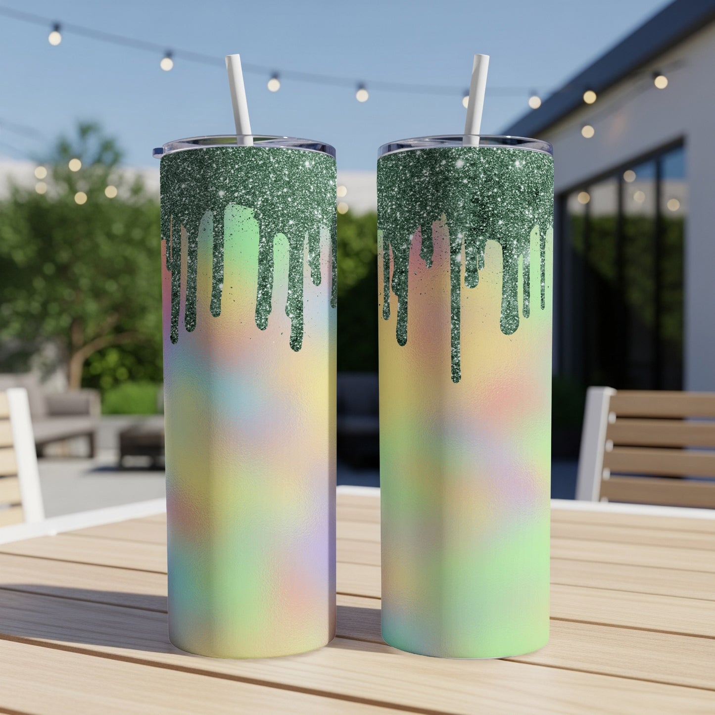Two tumblers with green glitter drip and pastel tie-dye design on outdoor table.