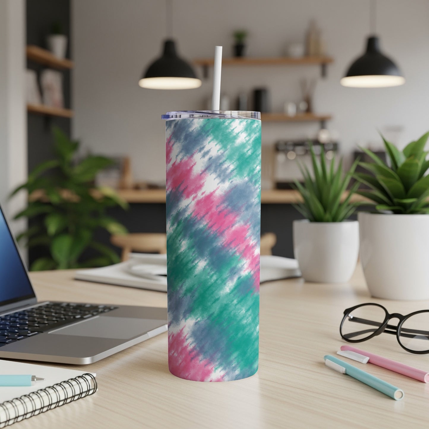 Tumbler with a pink, teal, and grey tie-dye pattern and a white straw.