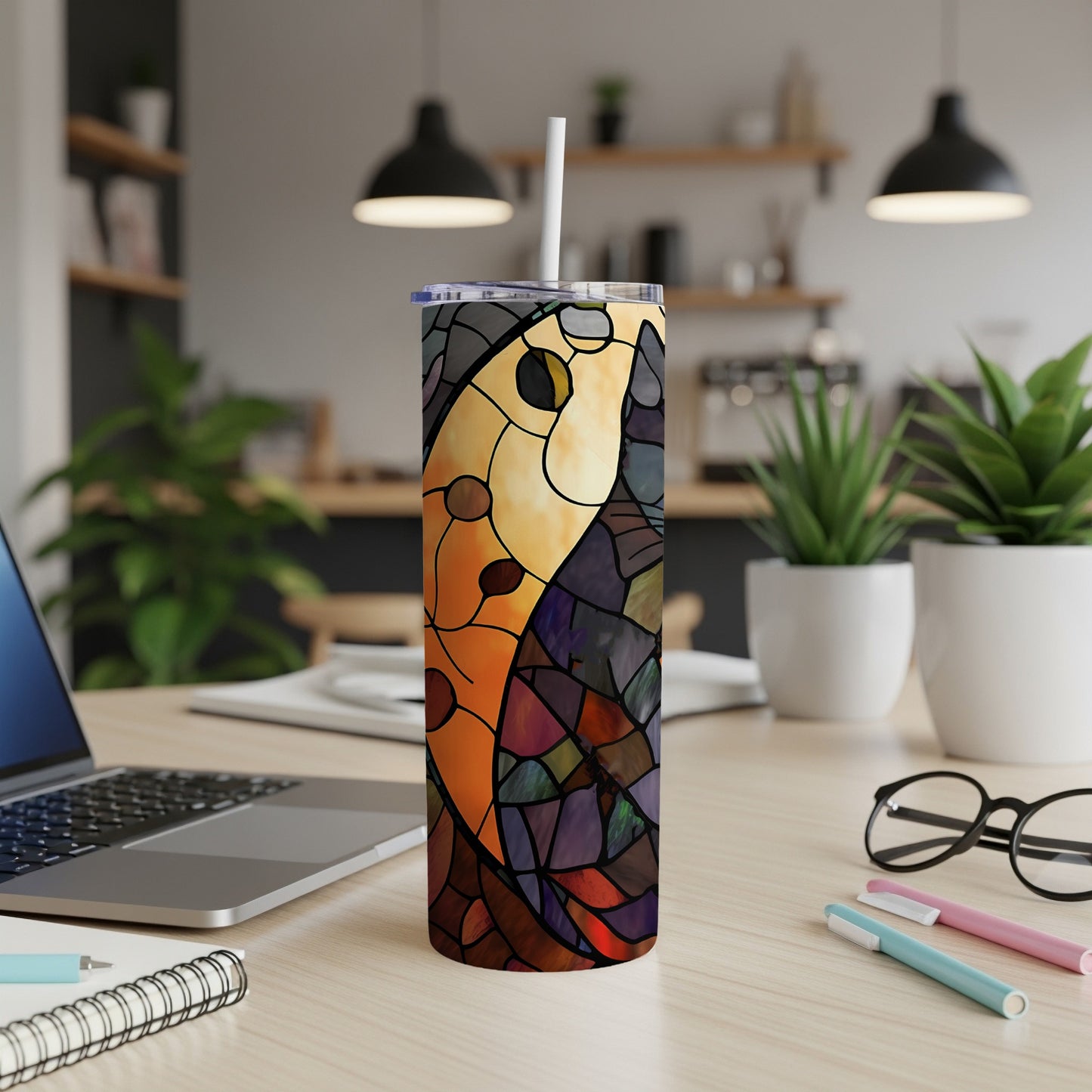 Tumbler with stained glass mosaic design of a bird on a desk.