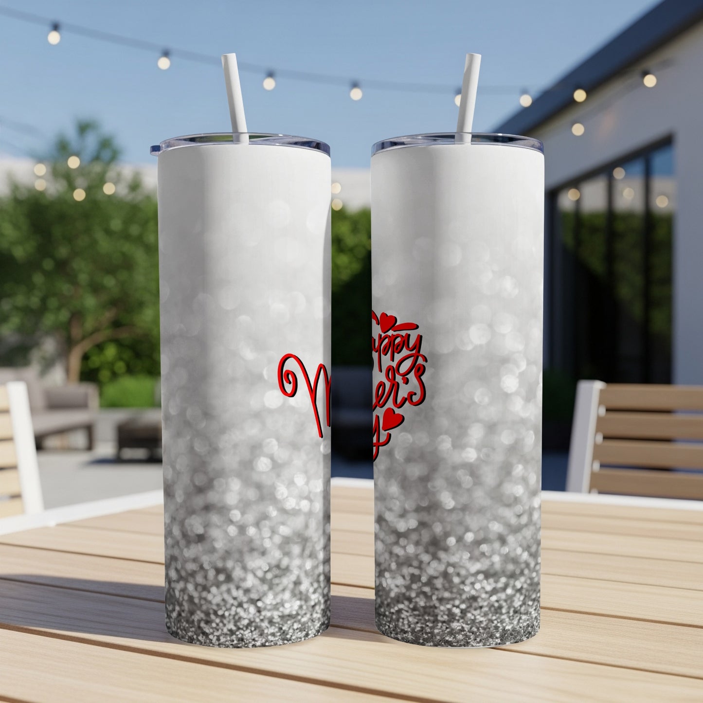 Glittery white tumbler with "Mom's Day" text, set on an outdoor table.