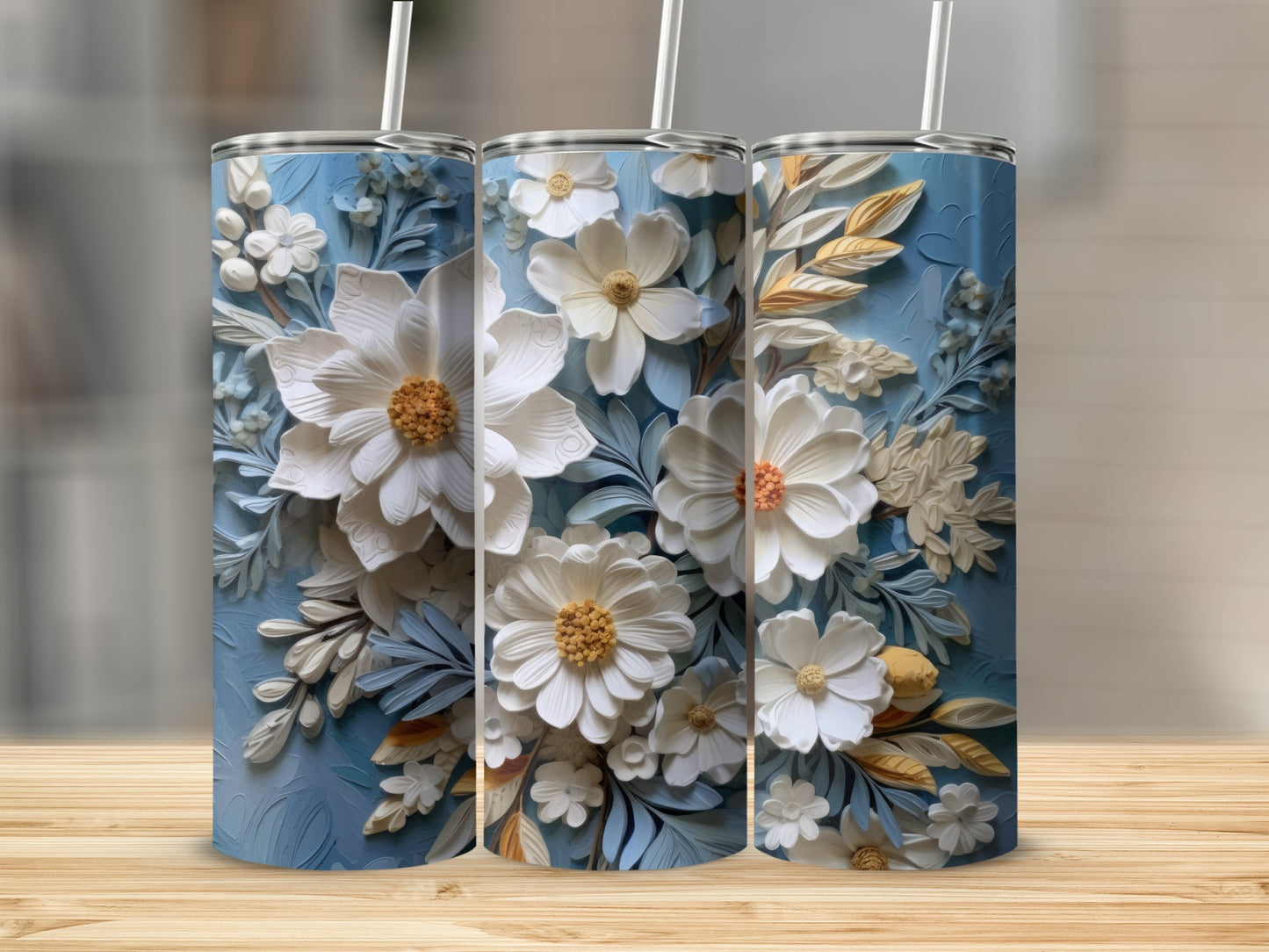 Three tumblers with white floral relief patterns on a textured blue background.