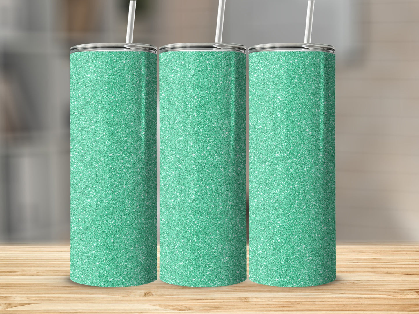 Three turquoise glitter tumblers with white straws stand on a wooden surface.