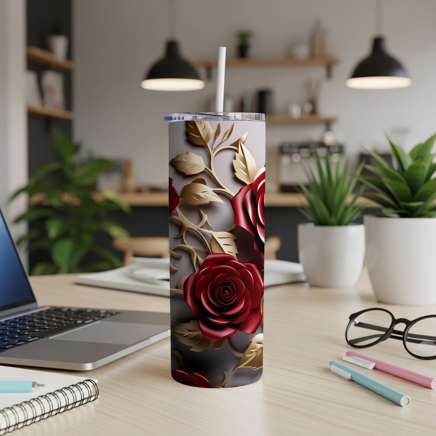 Red roses and gold leaves on a grey tumbler with a straw.