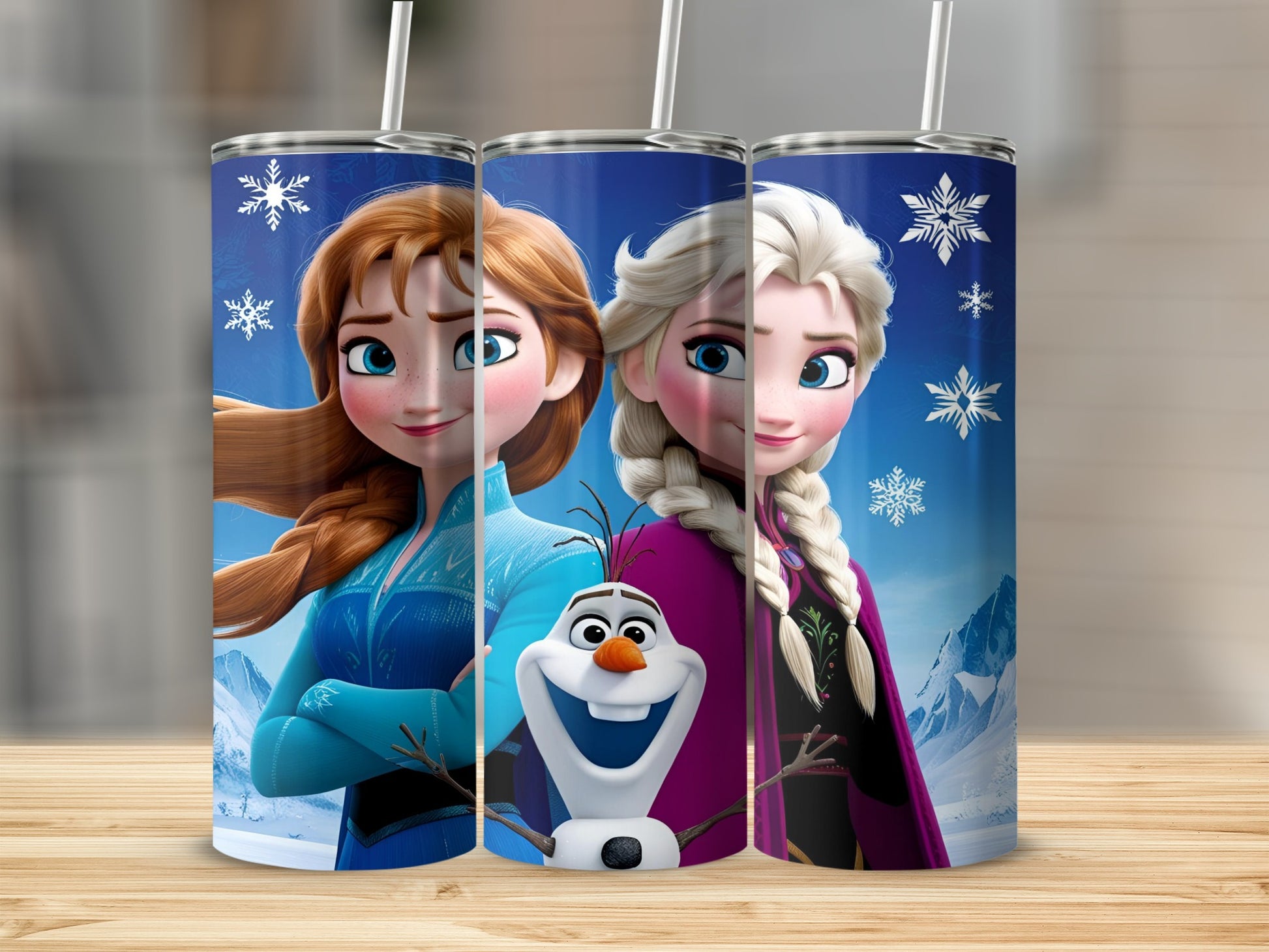 Three Frozen tumblers featuring Anna, Elsa, and Olaf on a wooden surface.