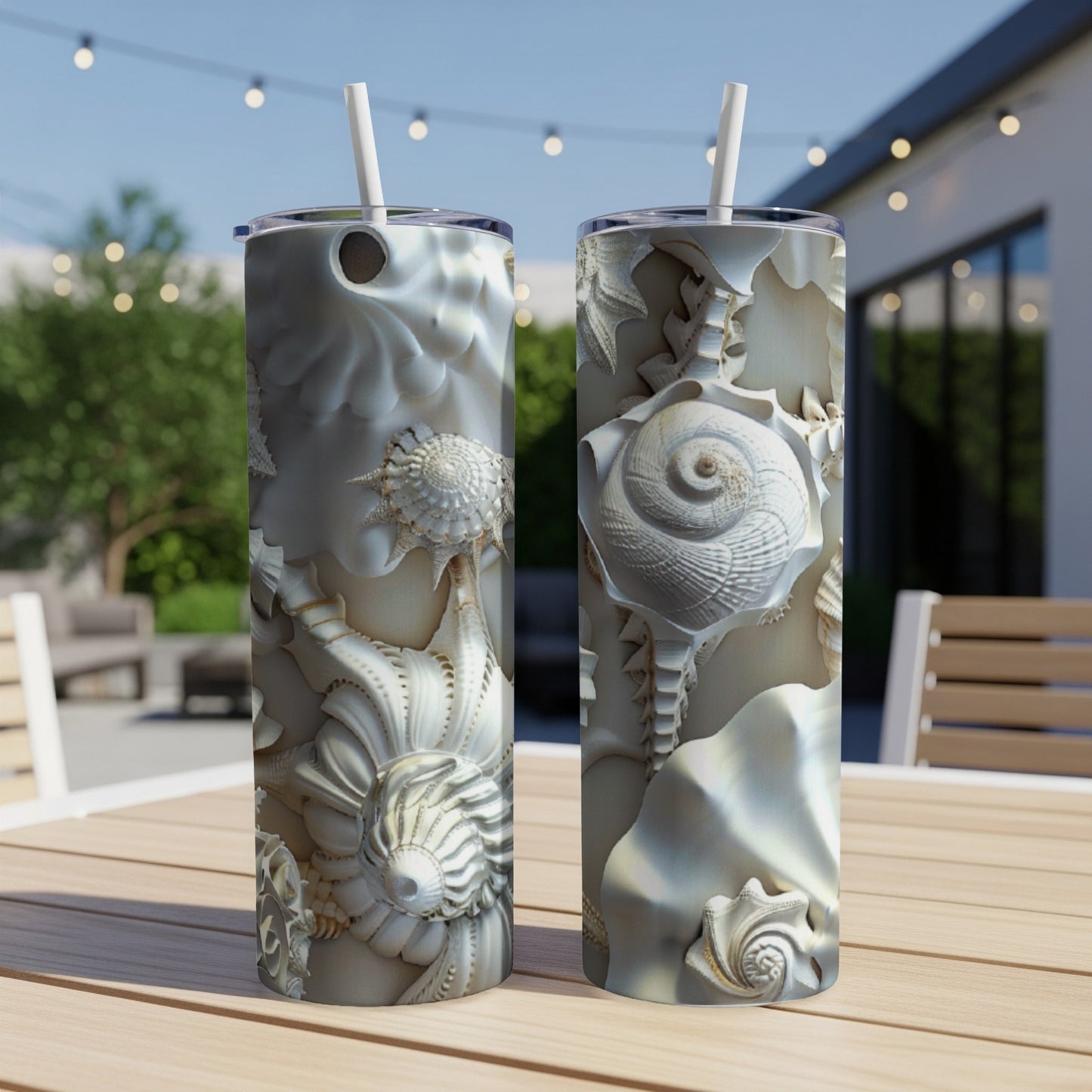 Two tall tumblers with intricate seashell patterns on a wooden table.
