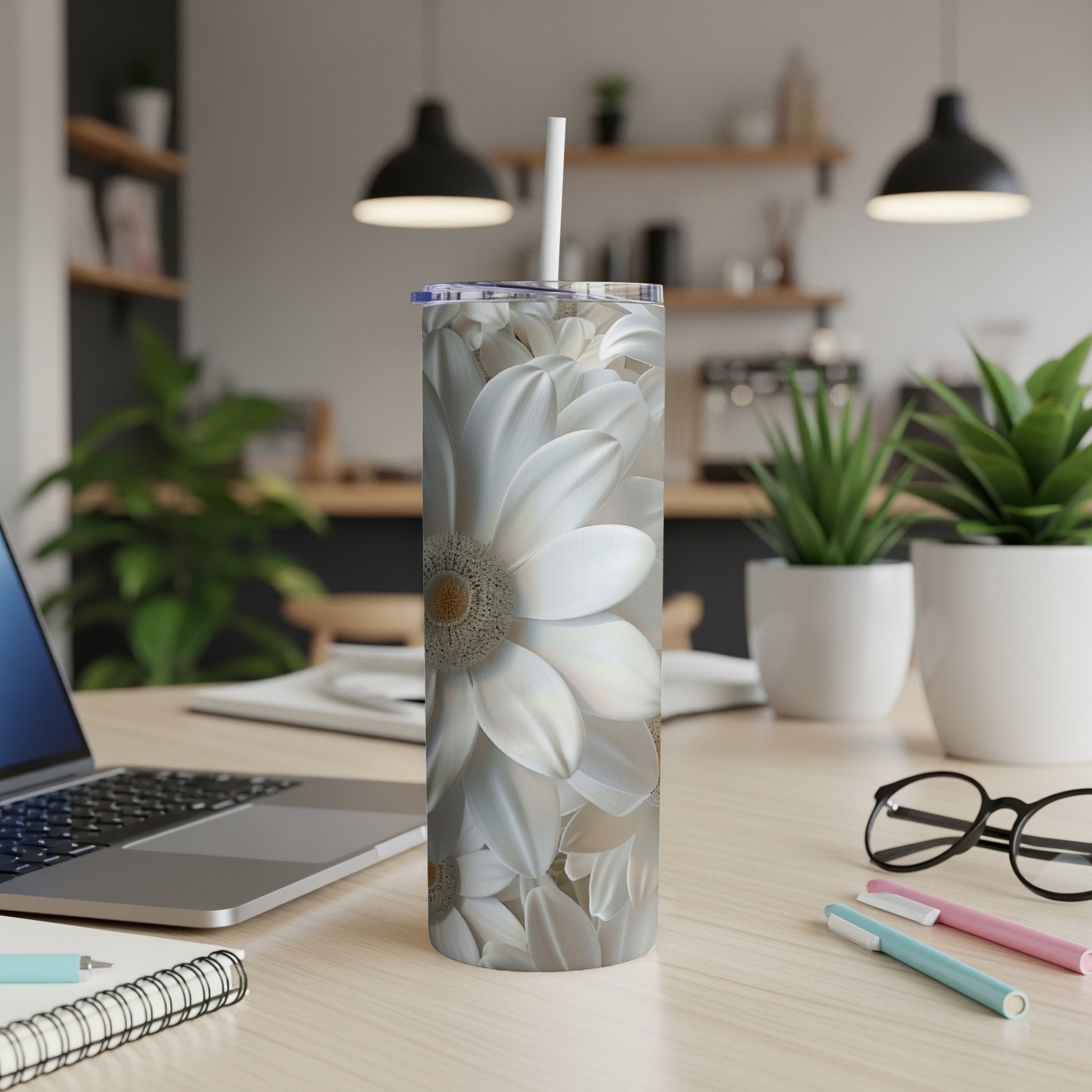 White floral pattern tumbler with straw on a desk.