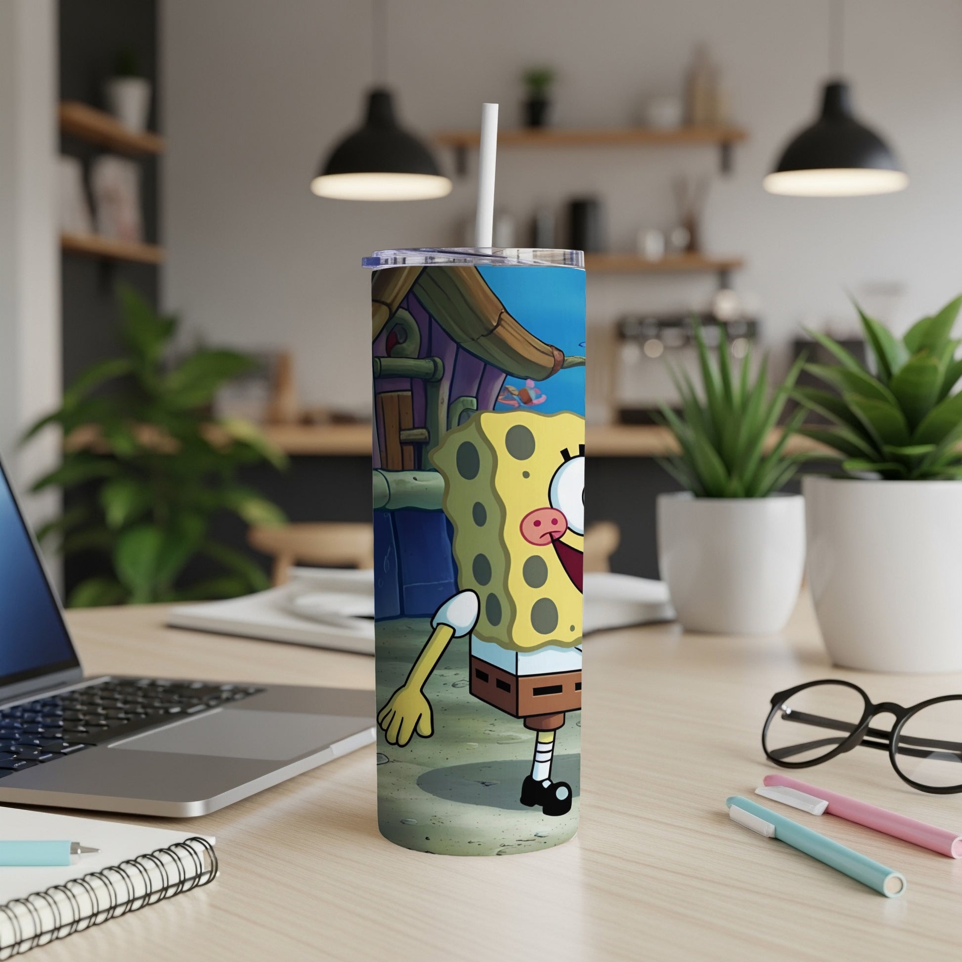 SpongeBob SquarePants character on a tumbler with a straw, on a desk.