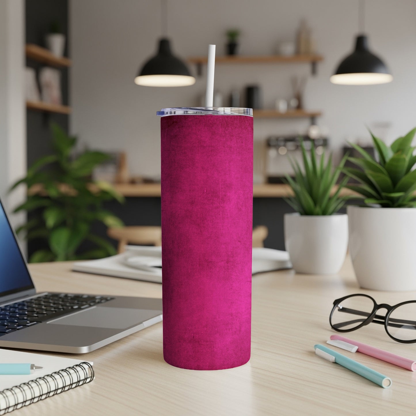 Pink textured tumbler with a white straw on a desk.