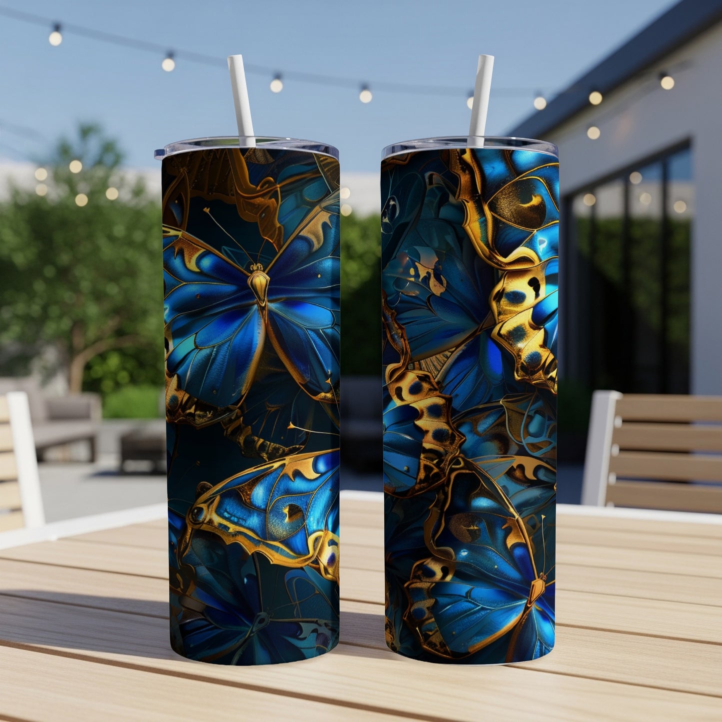 Two tumblers with a blue and gold butterfly pattern on a patio table.