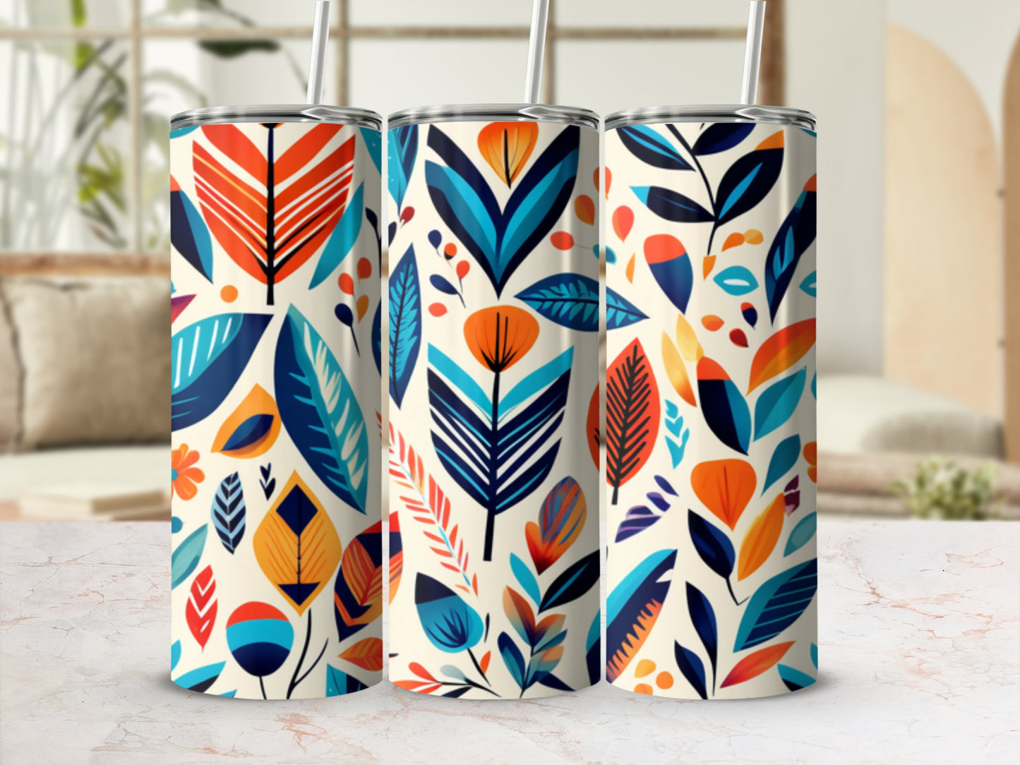 Three tumblers with a vibrant, abstract floral pattern on a light countertop.