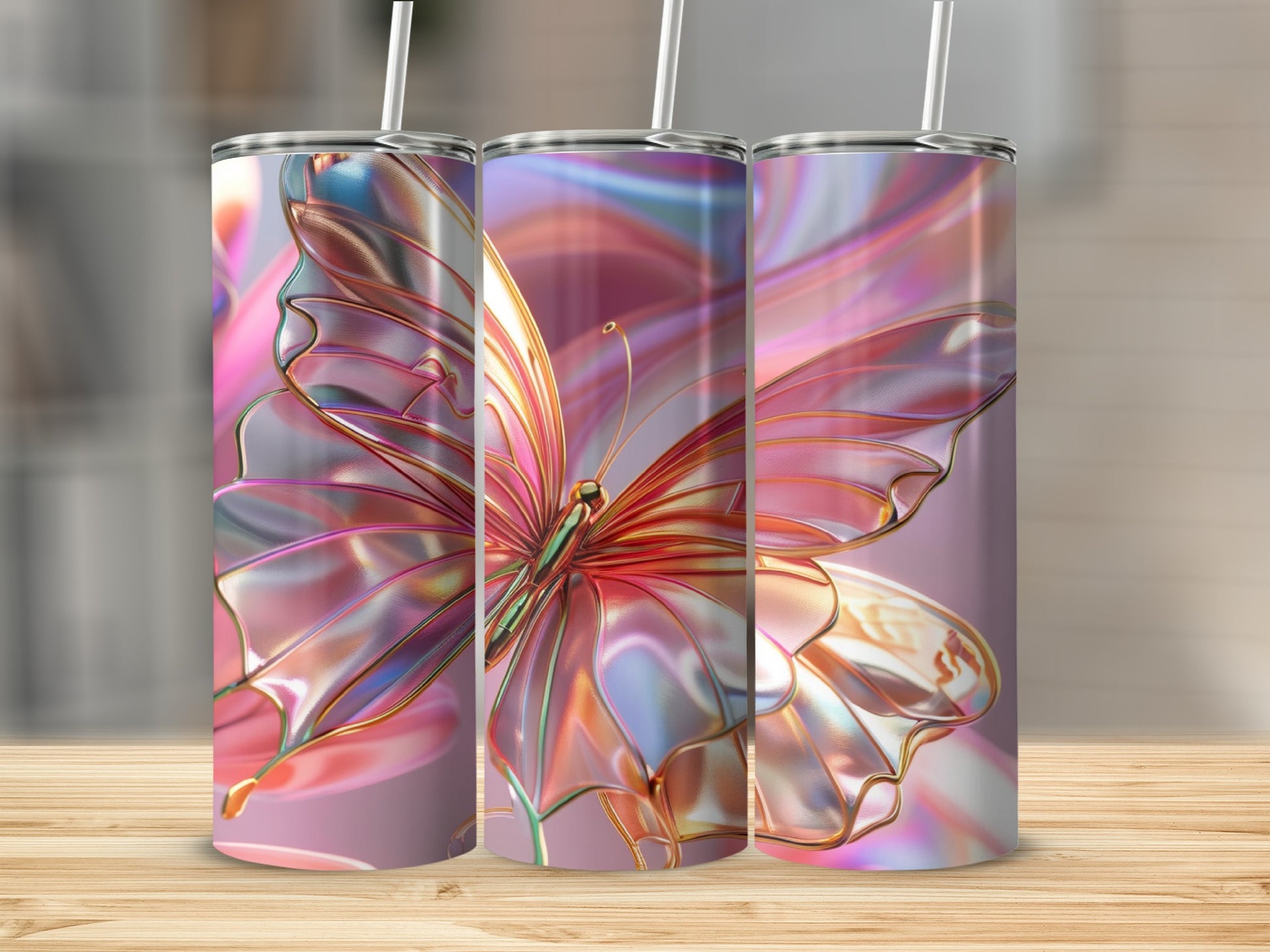 Three tumblers with iridescent butterfly wings design on a wooden surface.
