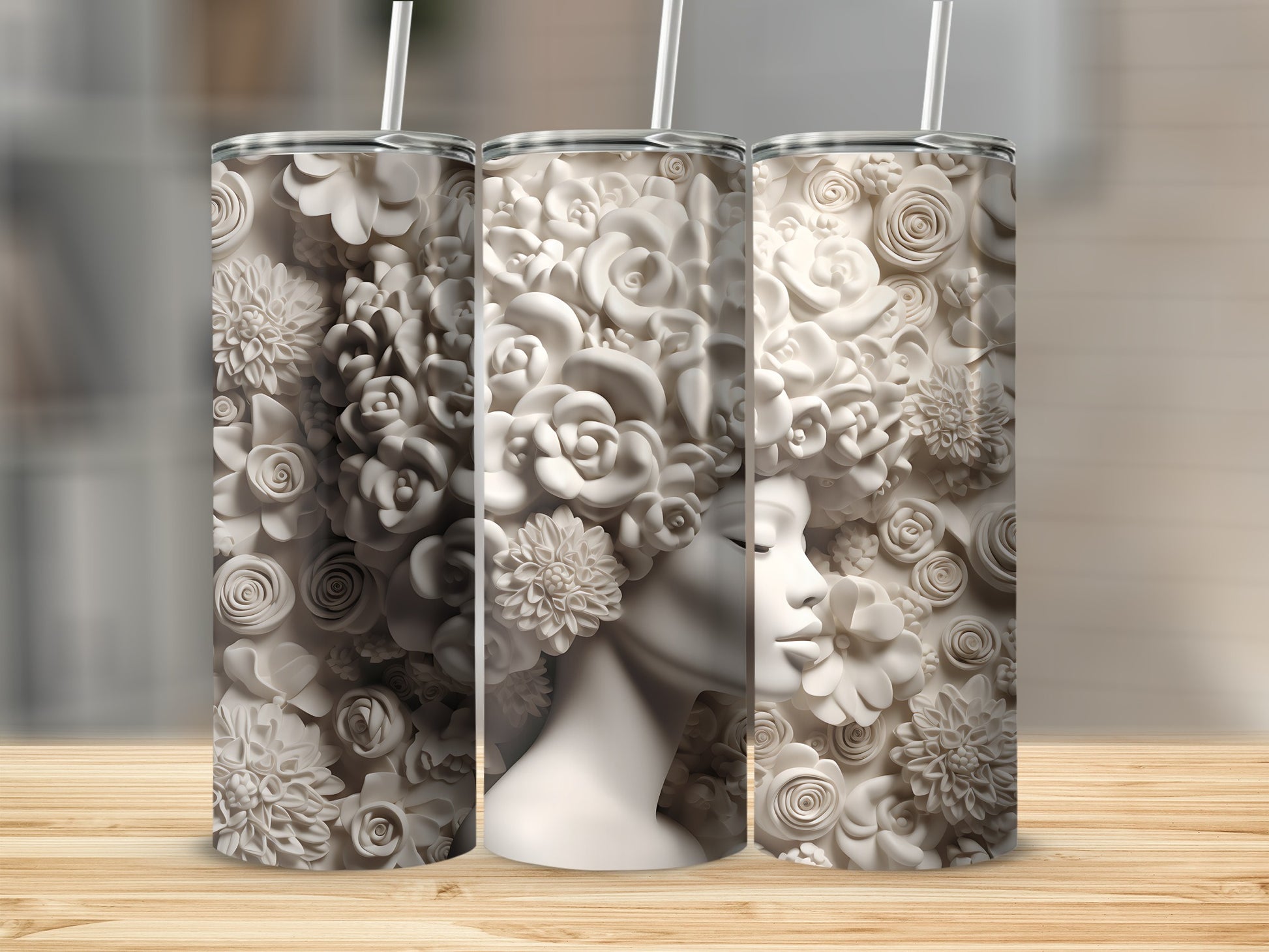 Three white tumblers with floral designs and a woman's profile.