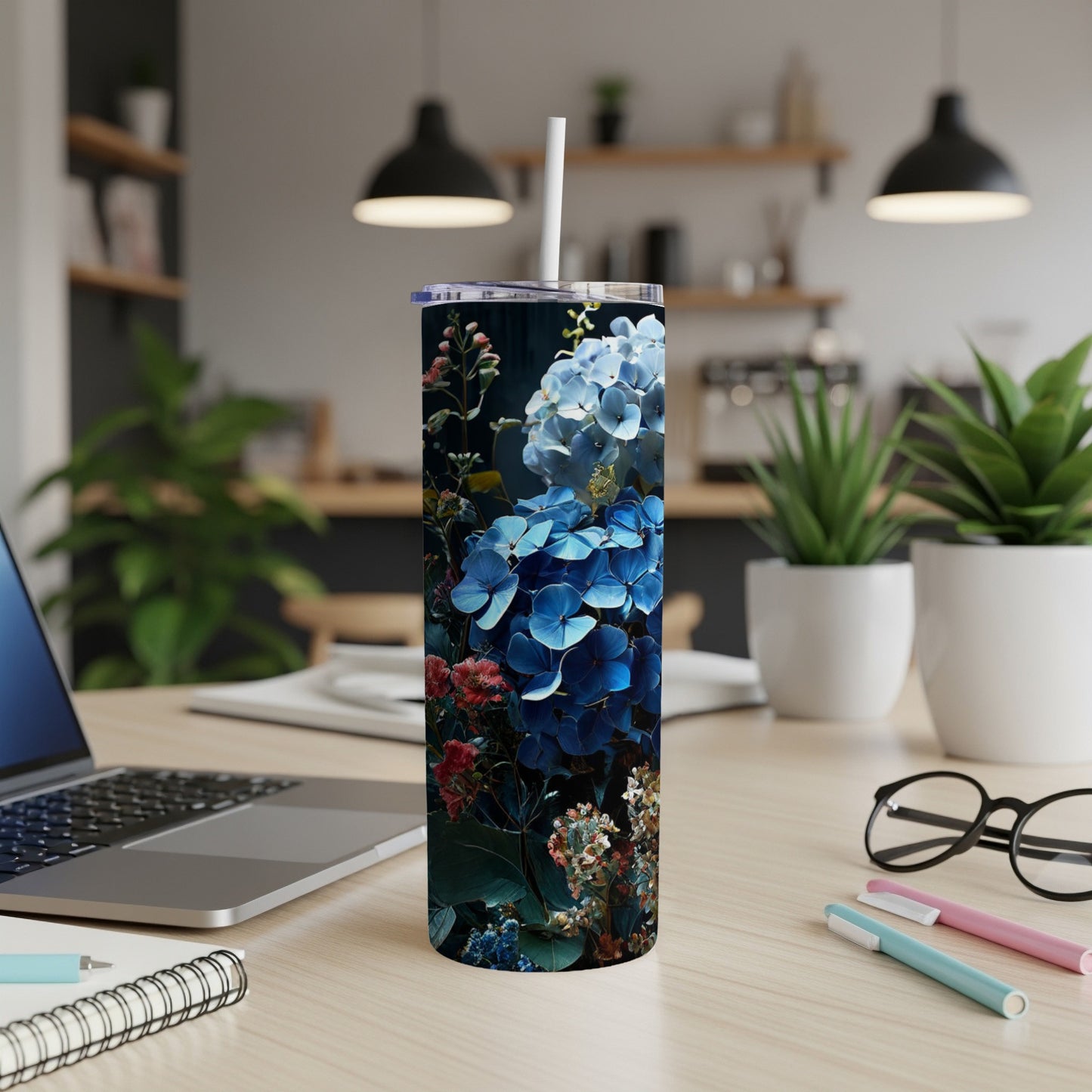 Blue hydrangea floral pattern on a tall tumbler with a straw.