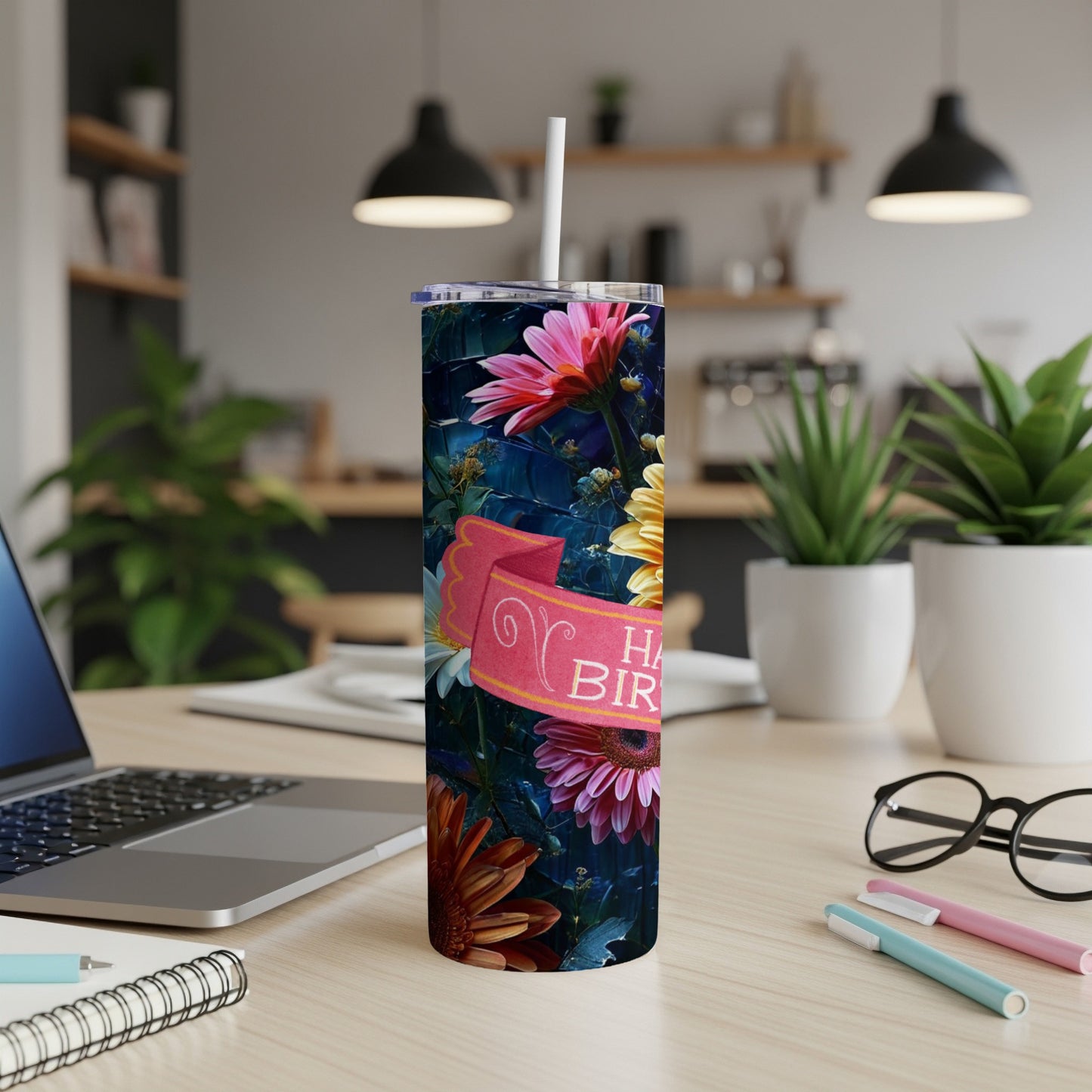 Floral tumbler with "Happy Birthday" banner on a desk.