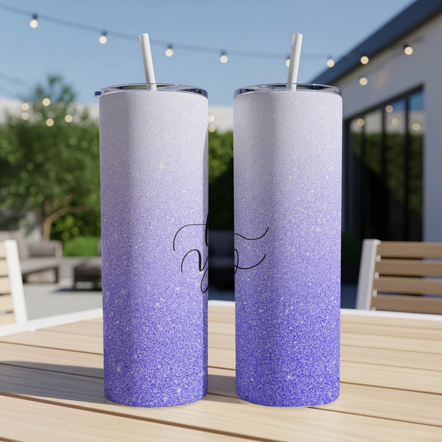 Two glitter-covered tumblers with purple and white ombre, standing on a wooden table.