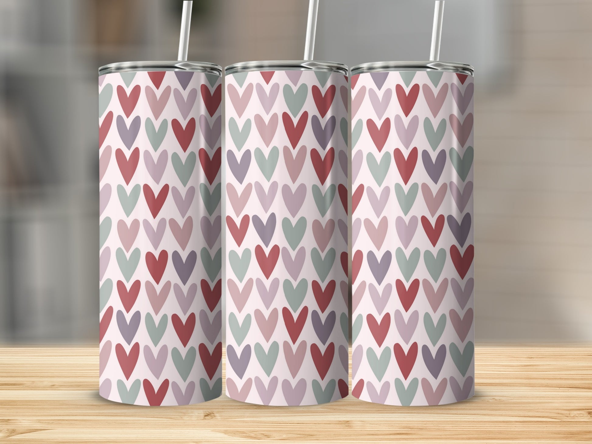 Three tall tumblers with a repeating pattern of small hearts in pink, purple, and grey.