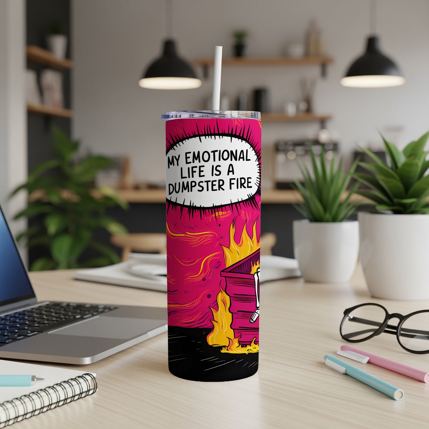 Tumbler with "My emotional life is a dumpster fire" text, on a desk.