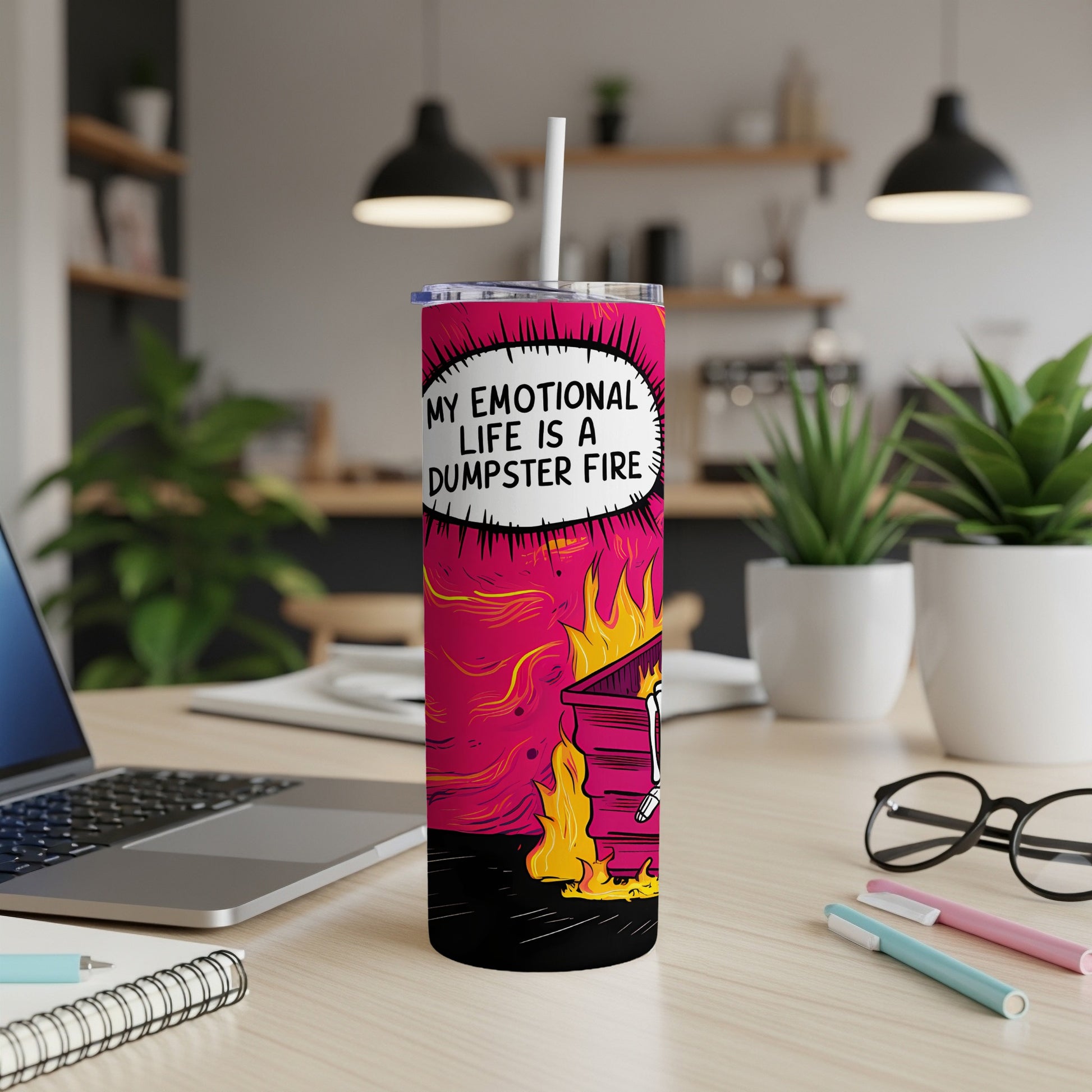 Tumbler with "My emotional life is a dumpster fire" text, on a desk.