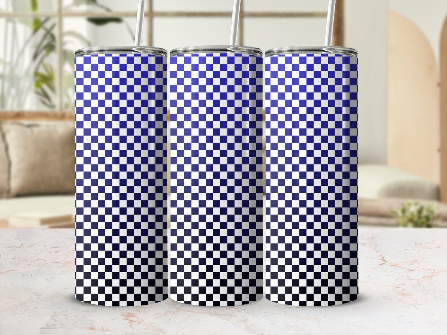 Three blue and white checkered gradient tumblers with straws on a marble surface.