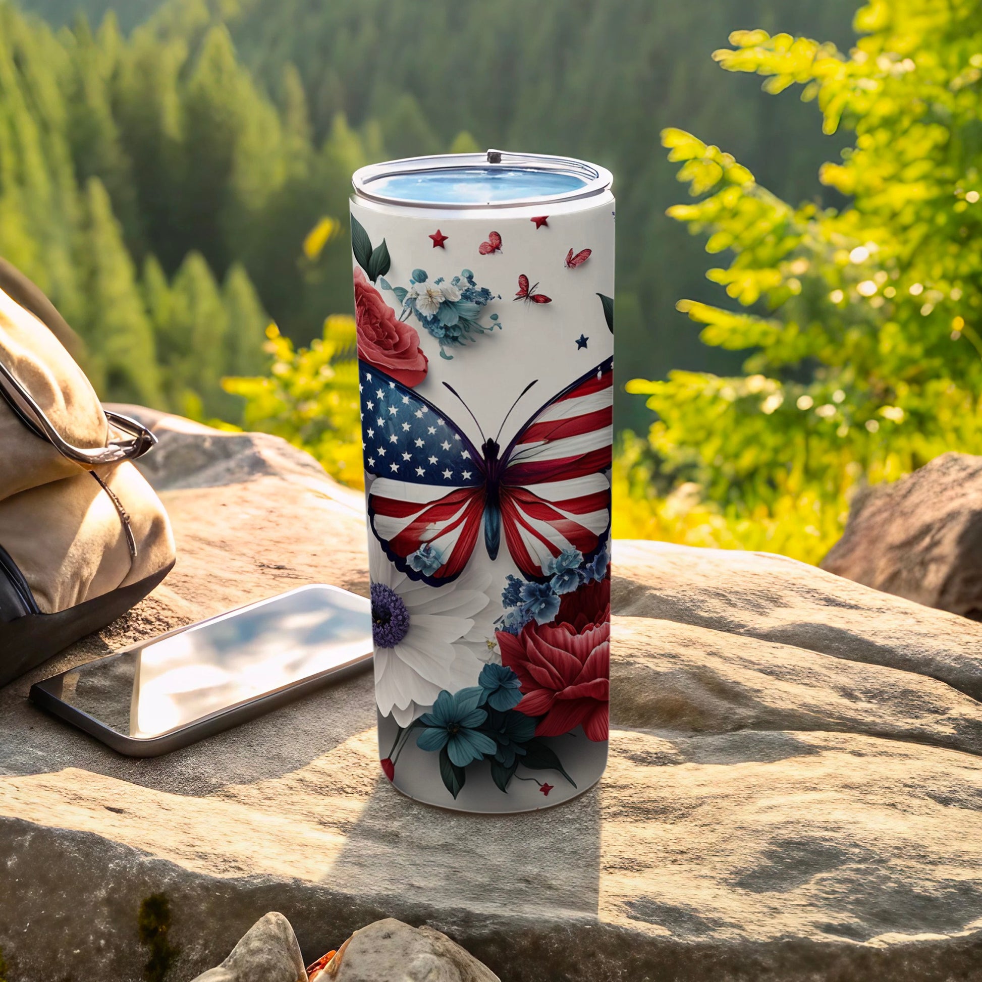 American flag butterfly tumbler with flowers and butterflies in outdoor setting.