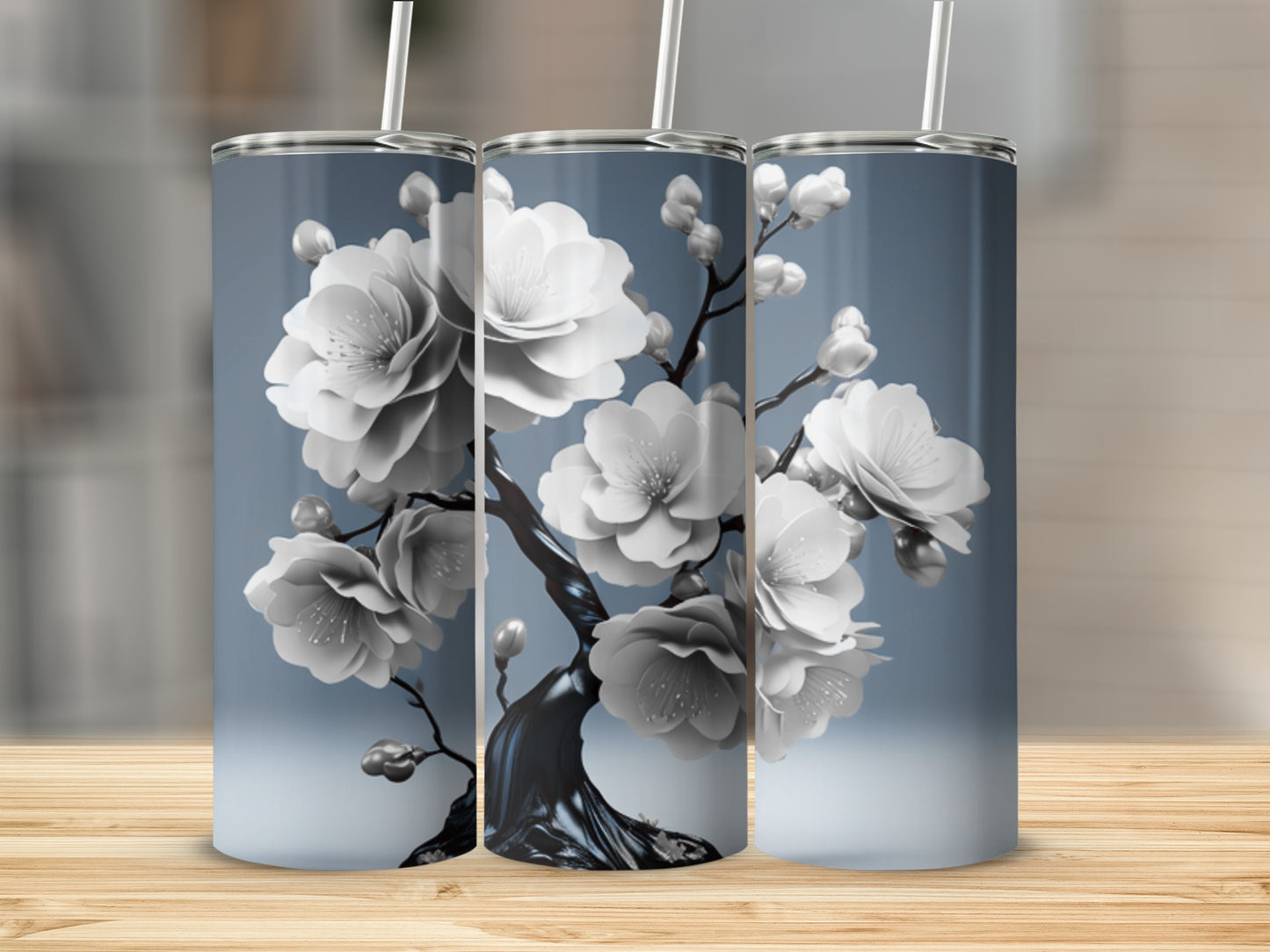Three tumblers with a white cherry blossom floral design on a gradient blue background.