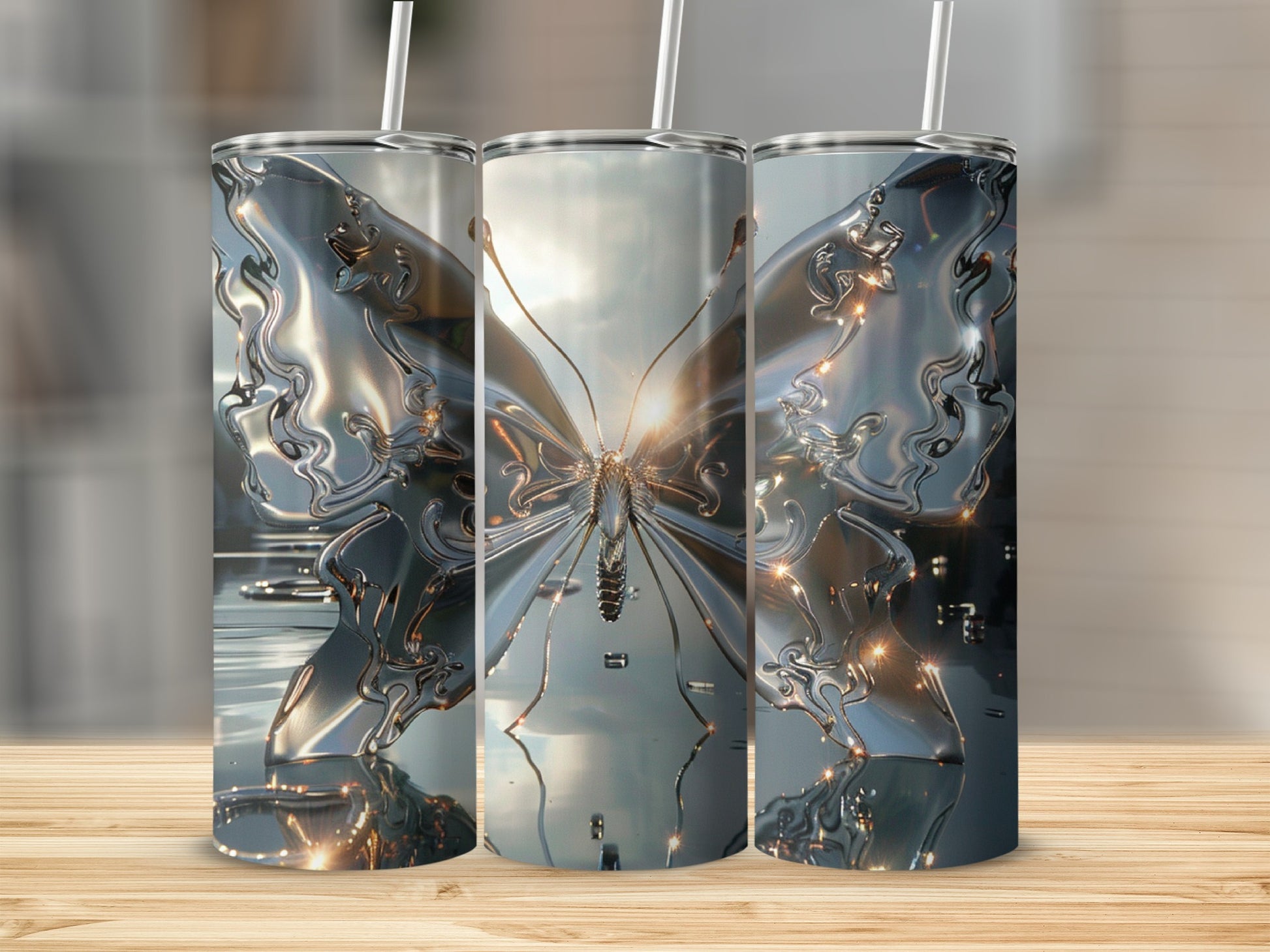 Three metallic butterfly tumblers with straws on a wooden surface.