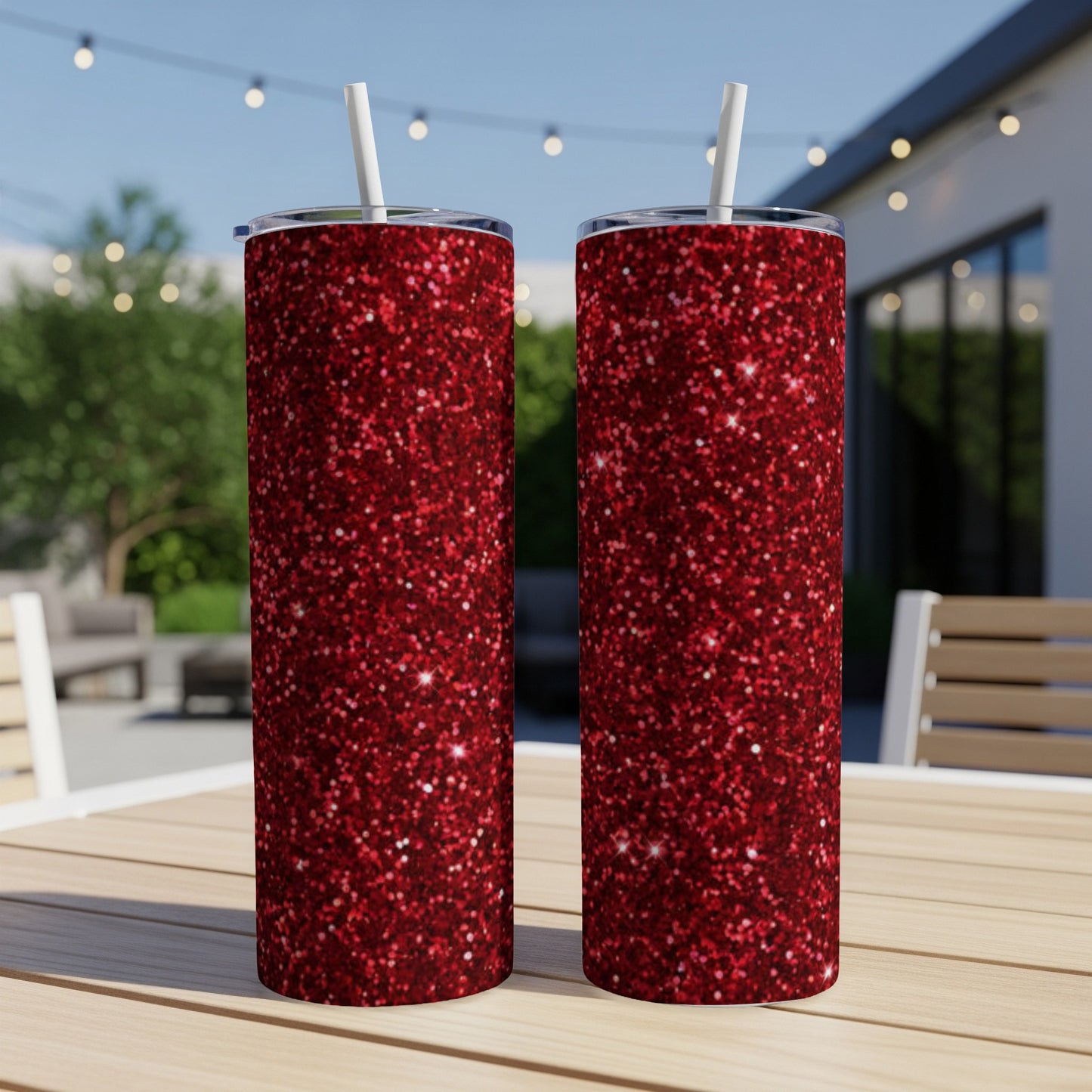 Two tall, slender tumblers with a red glitter design stand on a table.