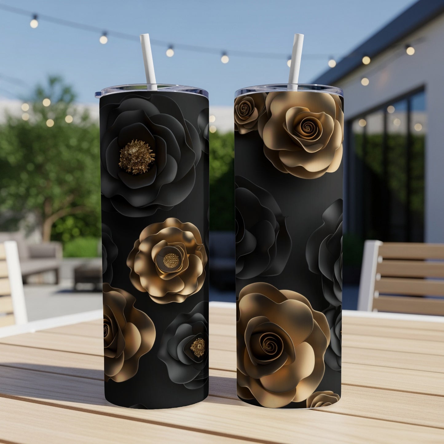 Two black tumblers with gold and black floral patterns stand on a table.