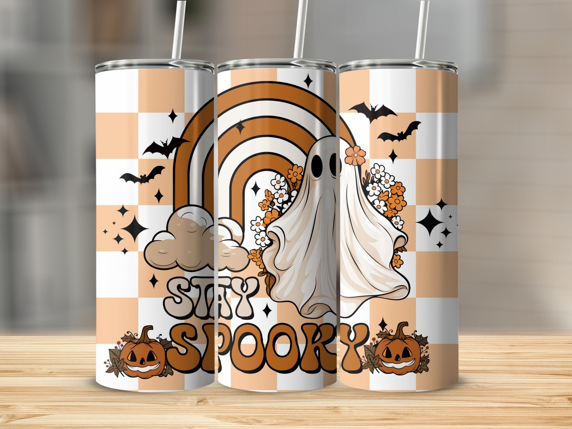 "Stay Spooky" tumbler with ghost, rainbow, bats, and pumpkins on checkerboard pattern.