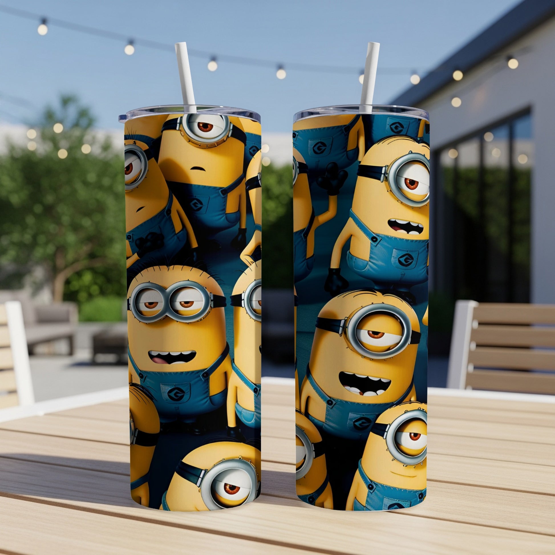 Two Minions-themed stainless steel tumblers with straws on a table.