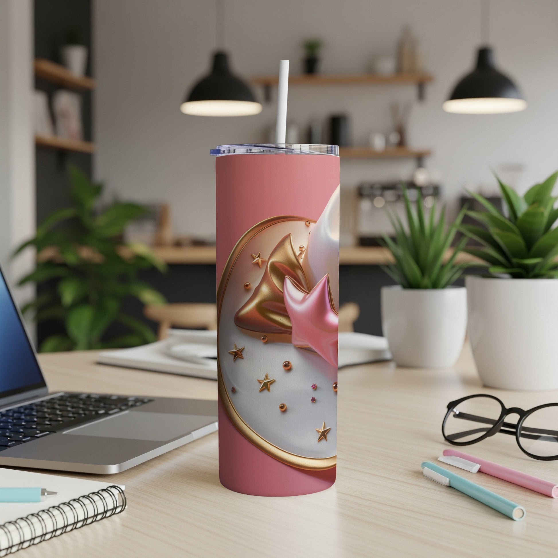 Pink tumbler with star and moon decorations on a desk.