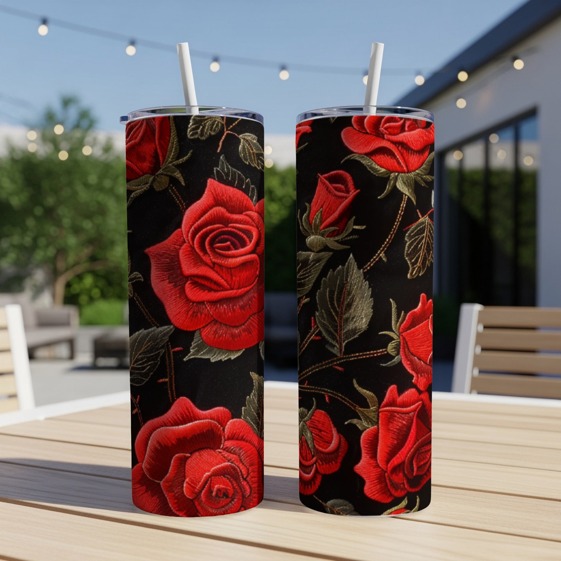 Two tall tumblers with red roses and green leaves on a black background.