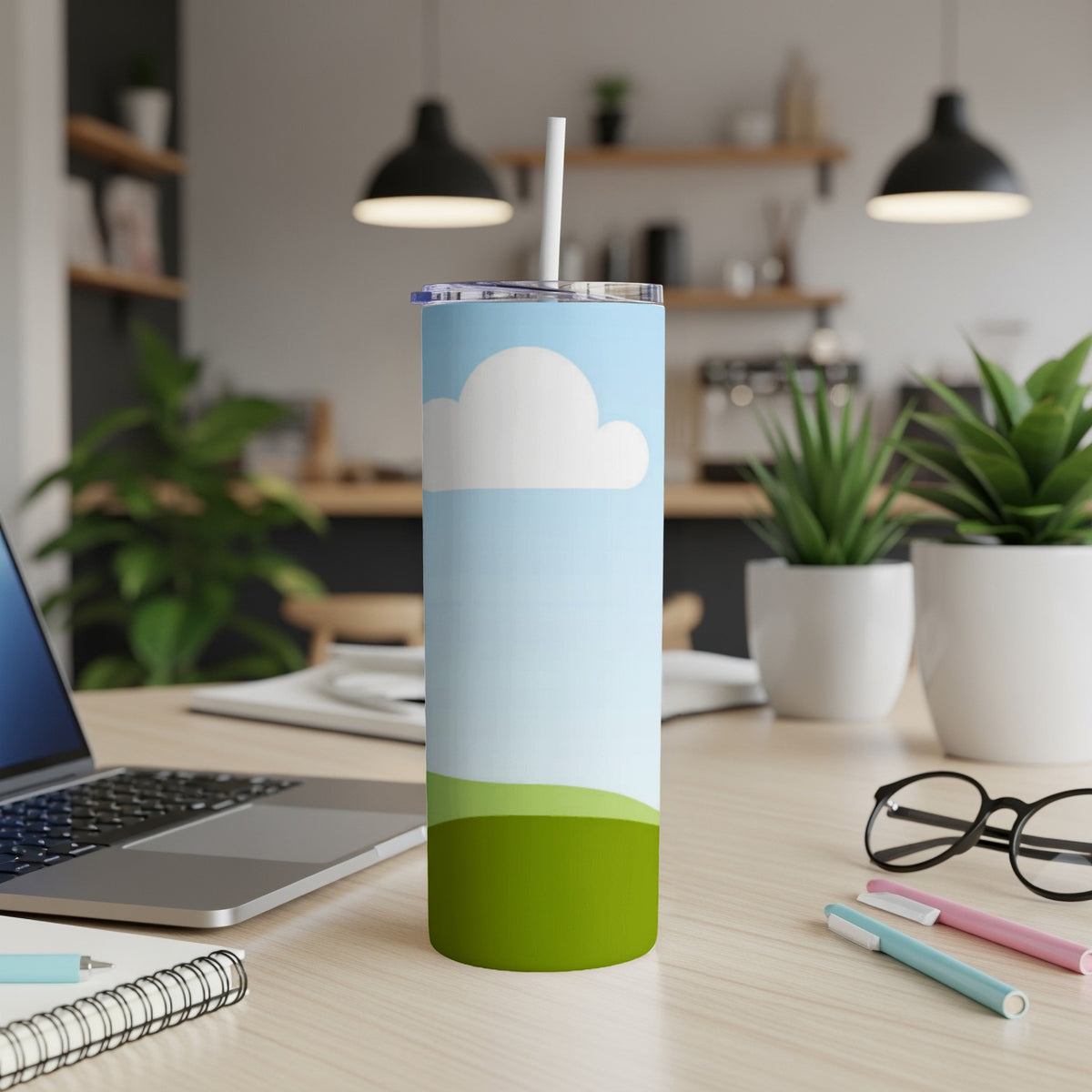 Tumbler with a sky and rolling green hills design, with a straw.