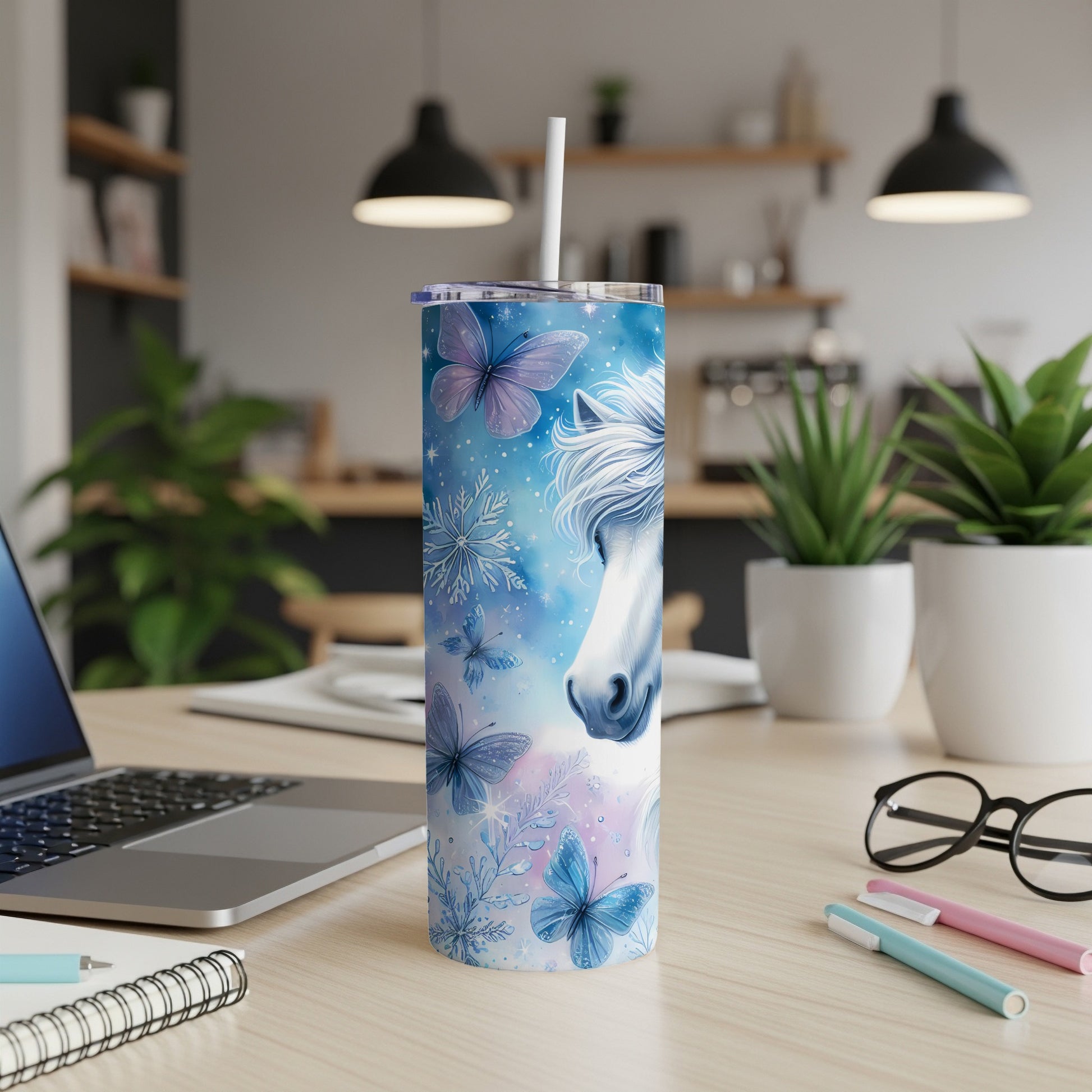 White unicorn with blue butterflies on a skinny tumbler with a white straw.