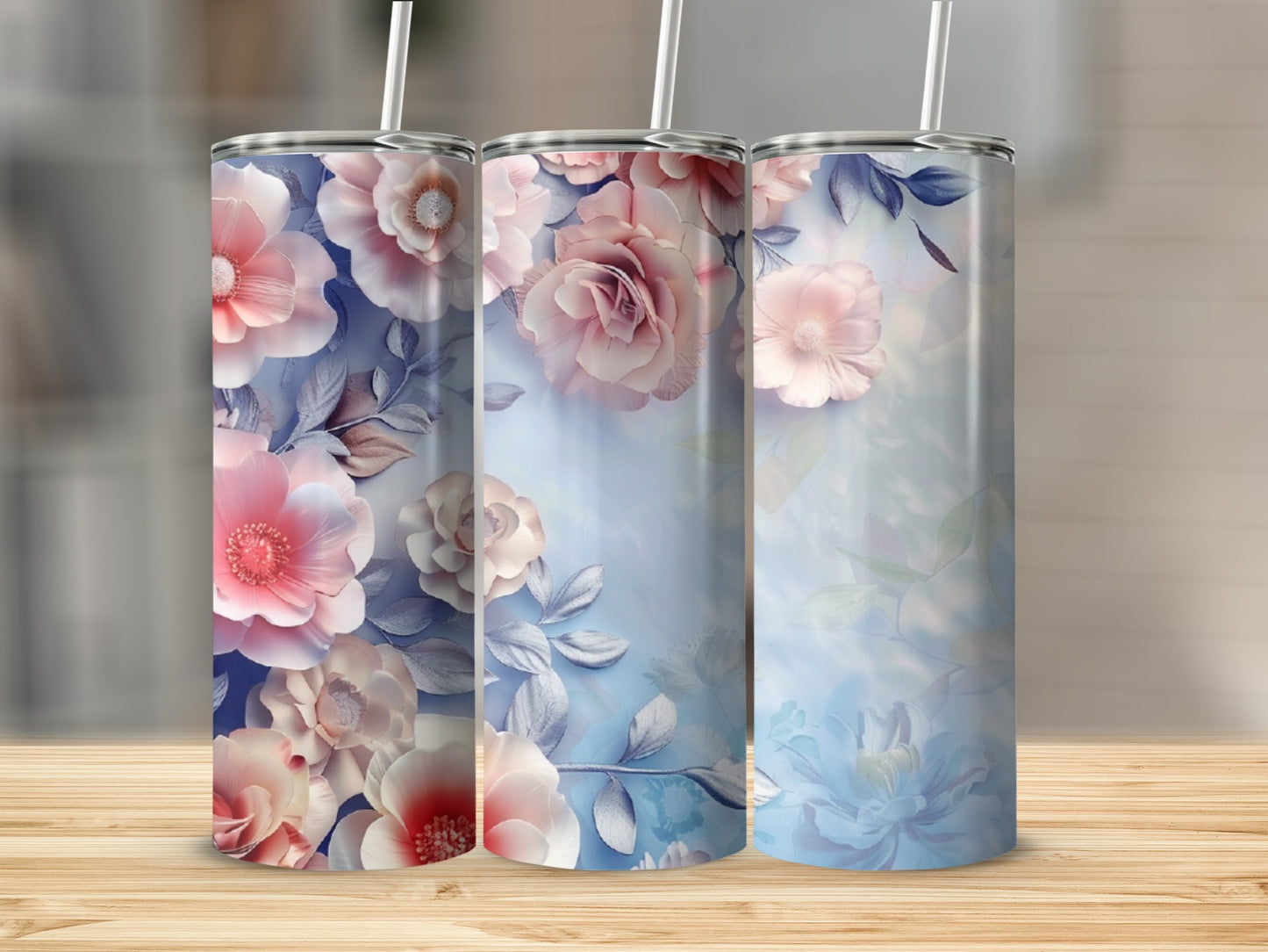 Three tumblers with floral designs, featuring pink and white roses and blue leaves.