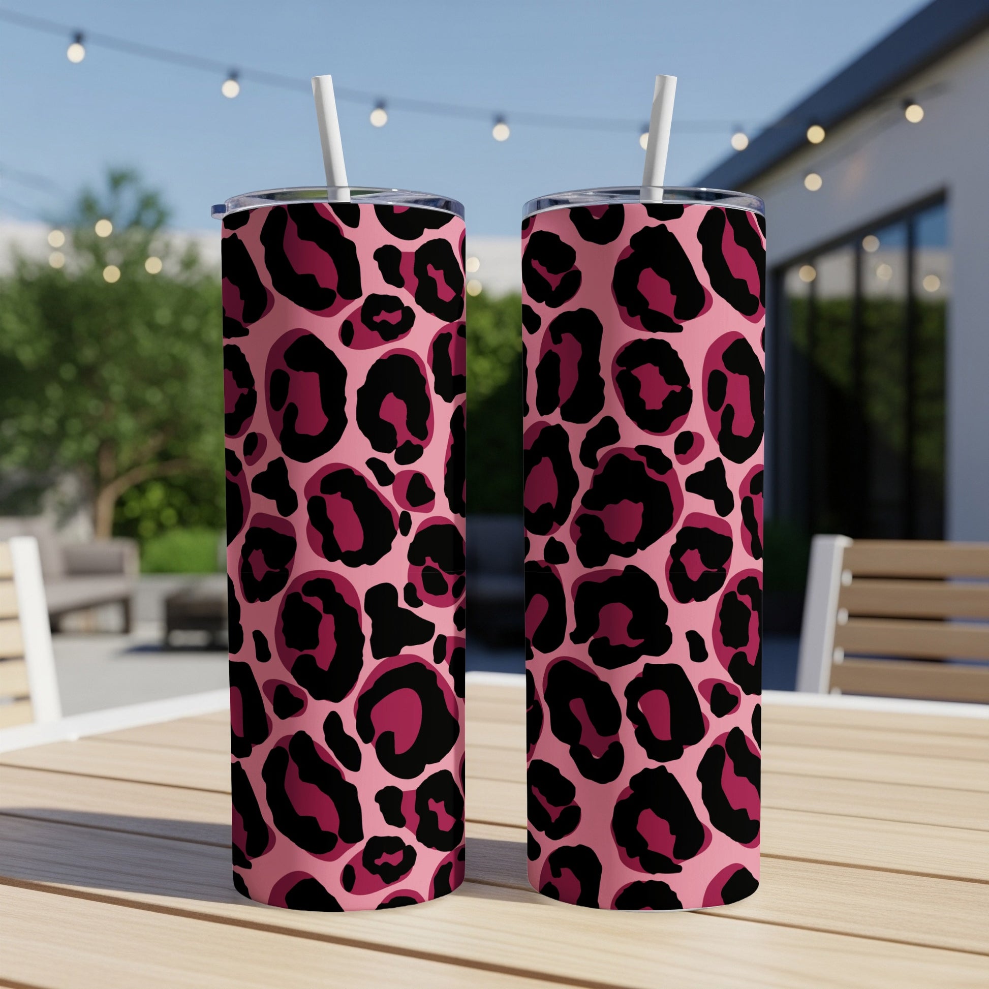 Two pink tumblers with black and deep pink leopard print and white straws.