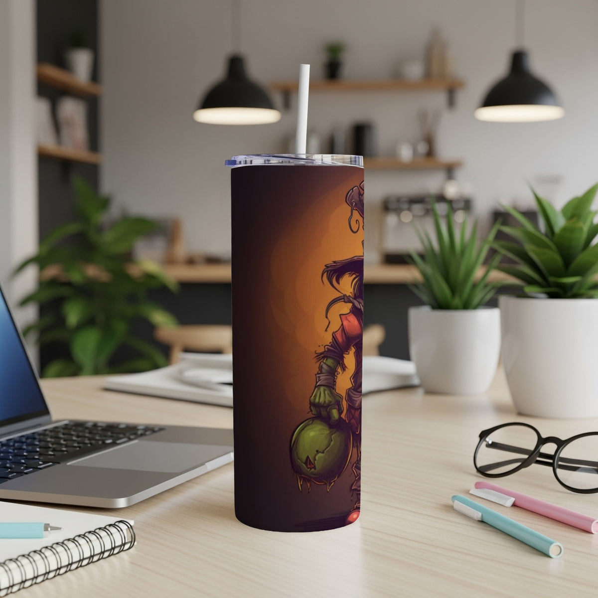 Tumbler with cartoon zombie holding a green orb, shown on a desk.