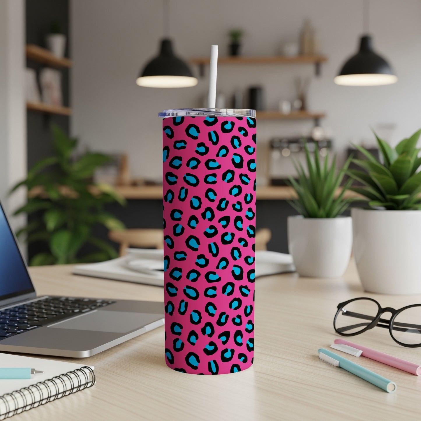 Pink tumbler with blue and black leopard print and a white straw.