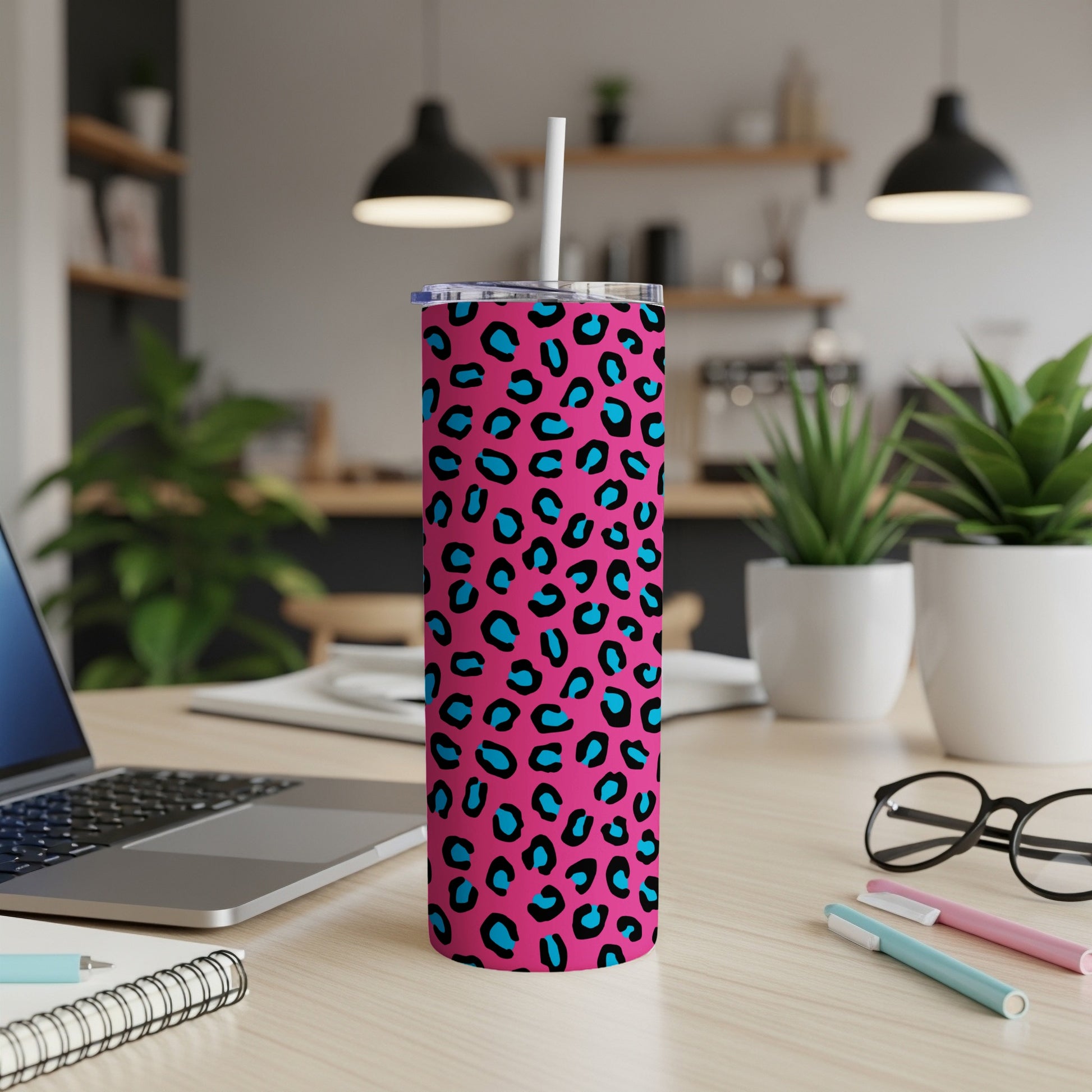 Pink tumbler with blue and black leopard print and a white straw.