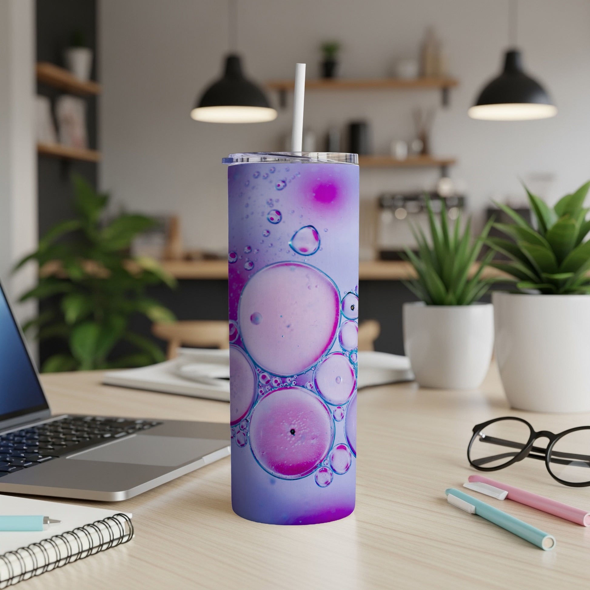 Purple and pink abstract bubbles design on a stainless steel tumbler.