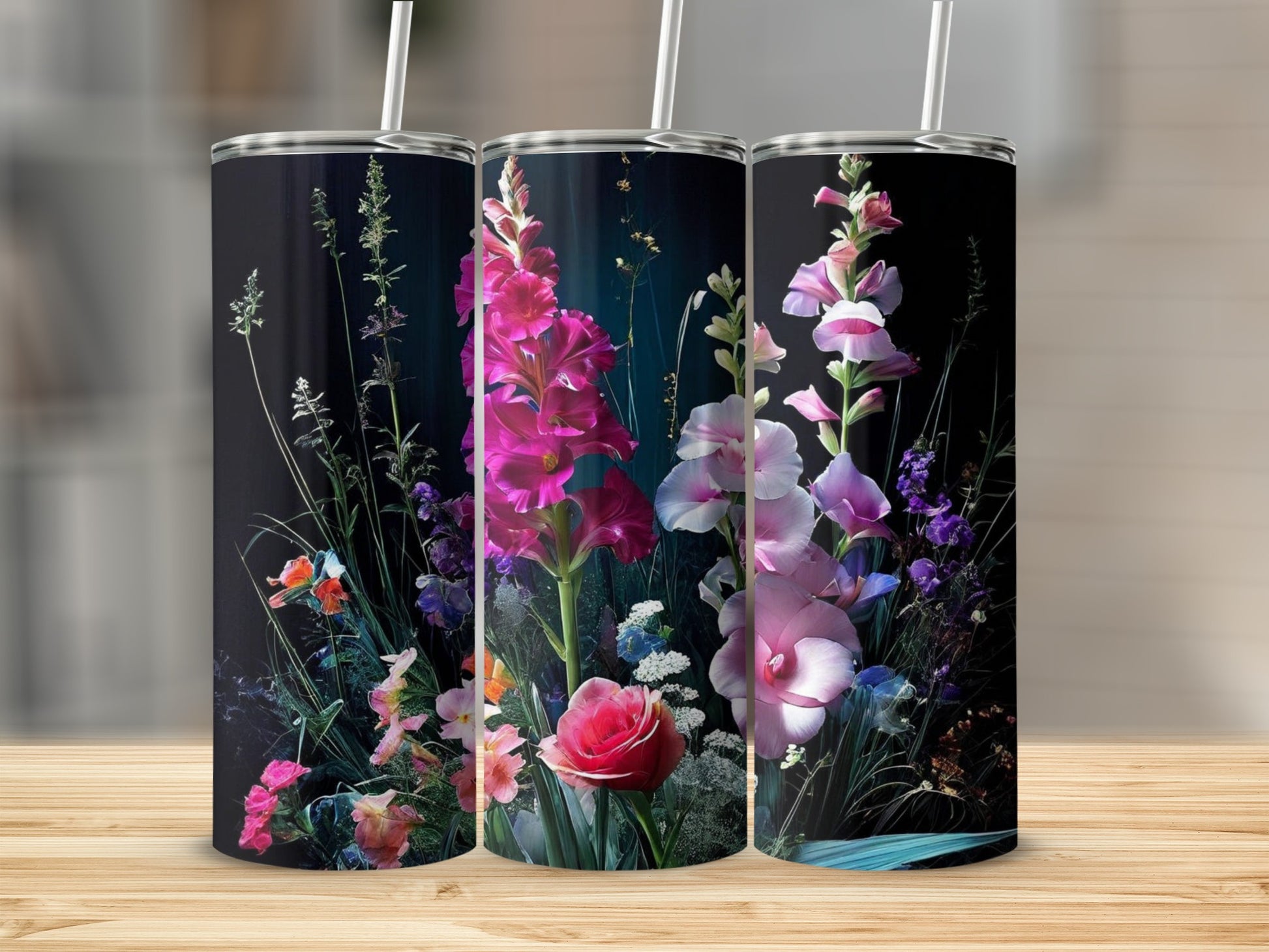 Three tumblers with a vibrant floral design against a dark background.