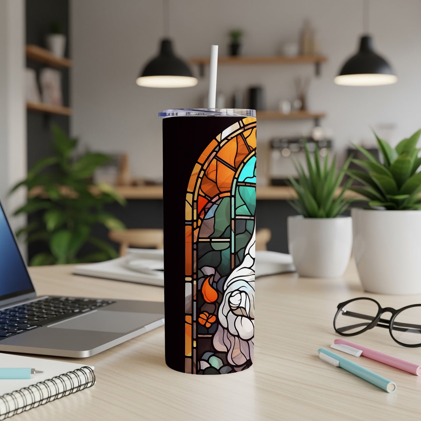Stained glass design on a dark tumbler with a straw.