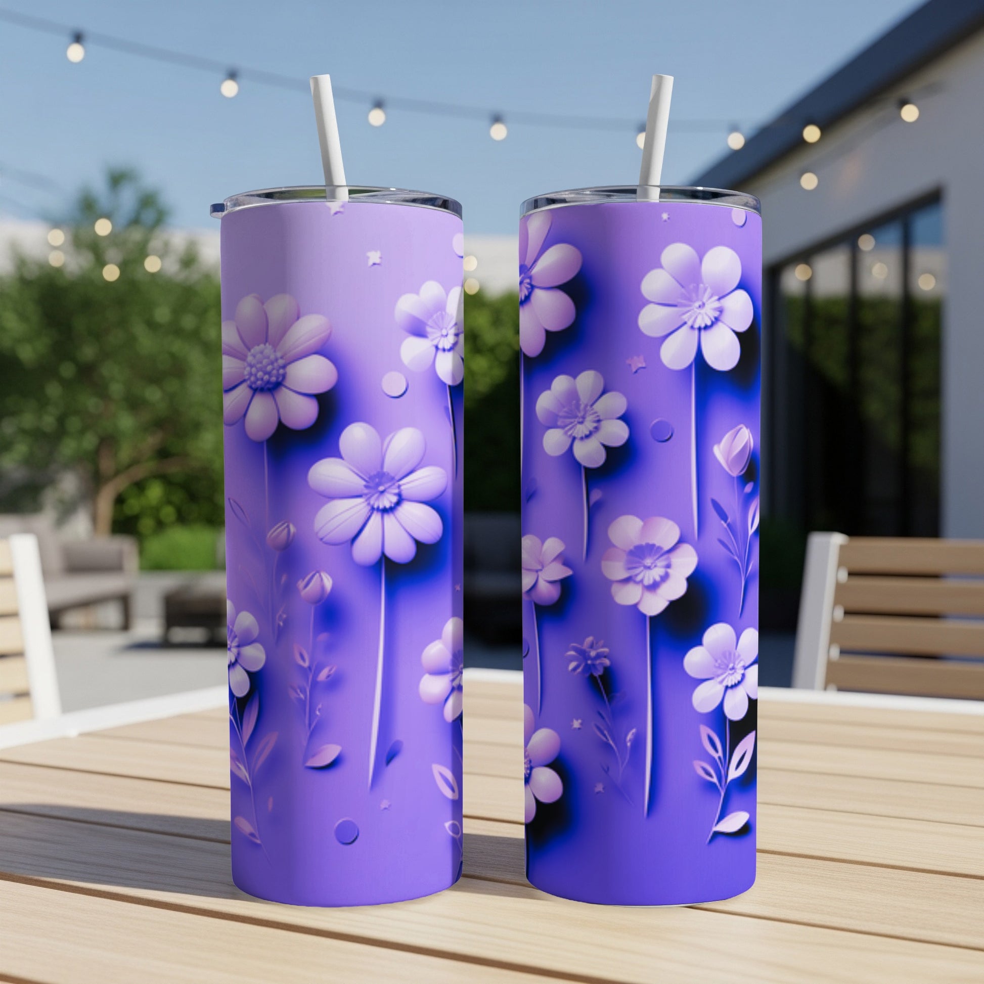 Two purple tumblers with white daisy floral pattern sit on a wooden table outdoors.