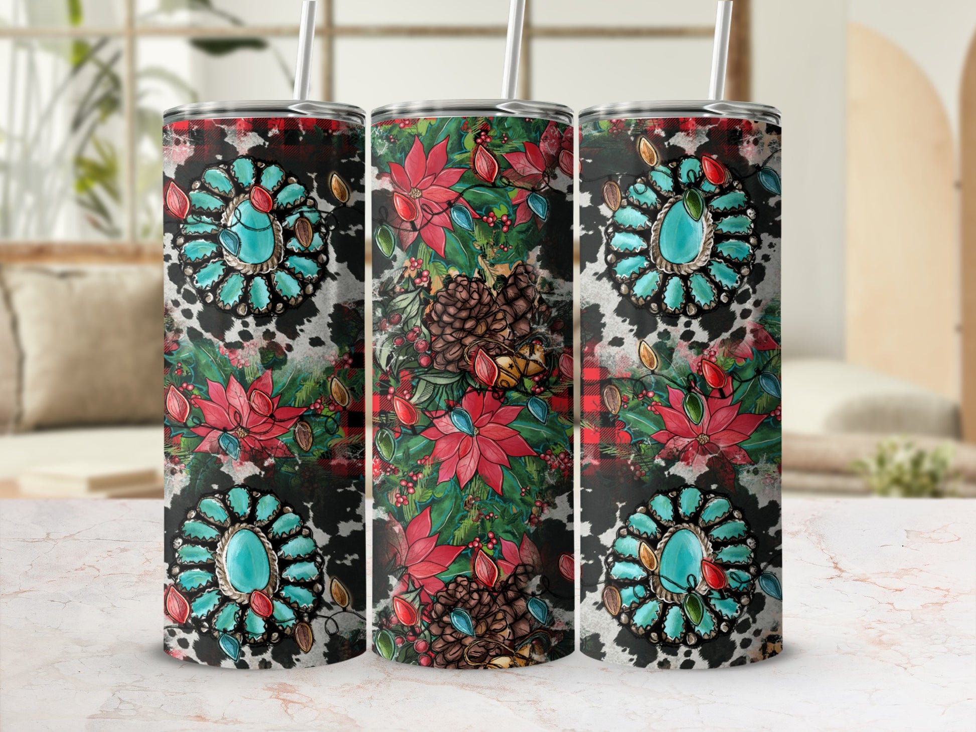 Three tumblers with floral, pinecone, and turquoise embellishments on a cow print background.