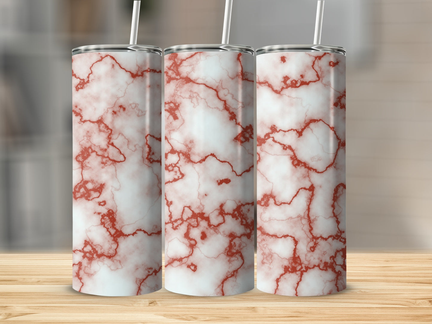 Three tumblers with red marble pattern on a wooden surface.