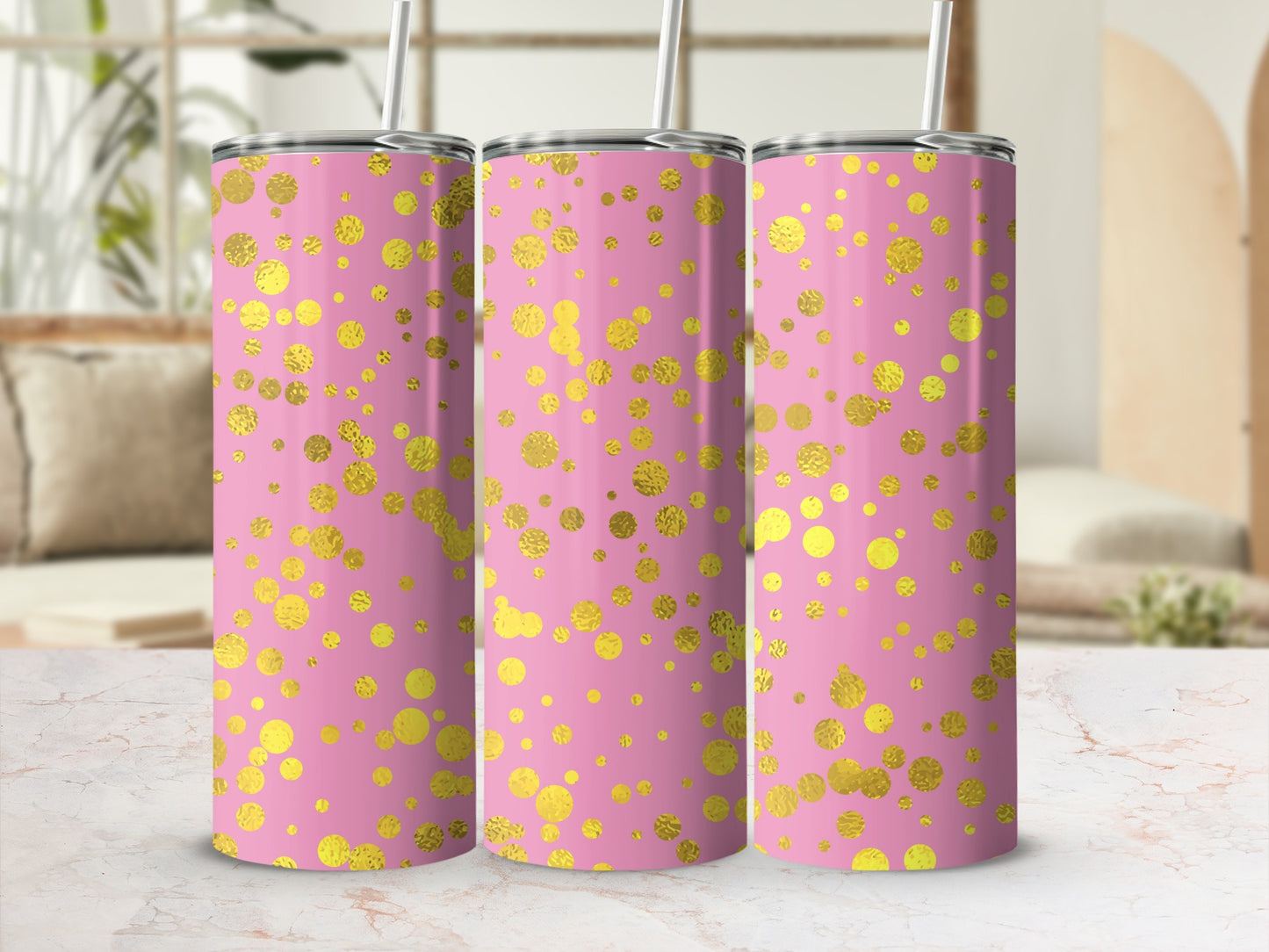 Three pink tumblers with gold polka dots and straws.