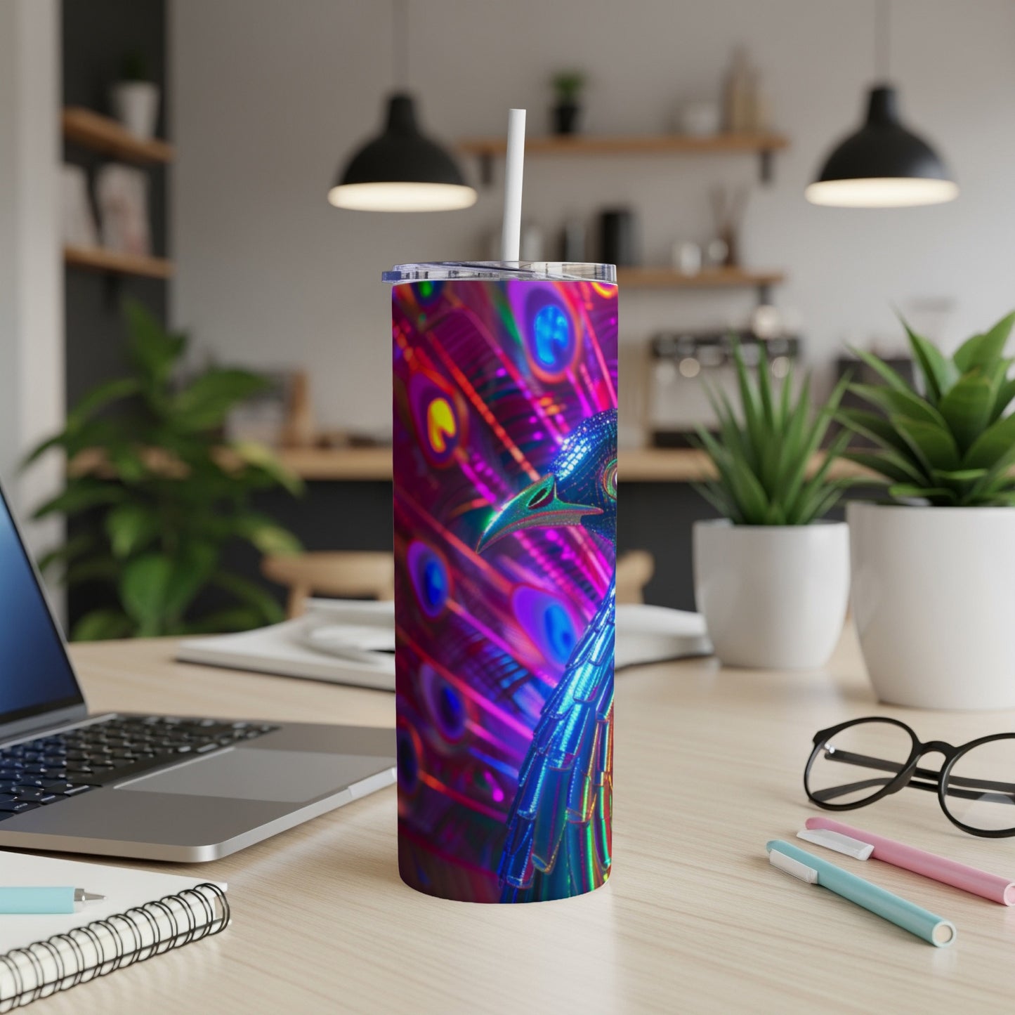 Tall tumbler with a metallic peacock design on a desk.