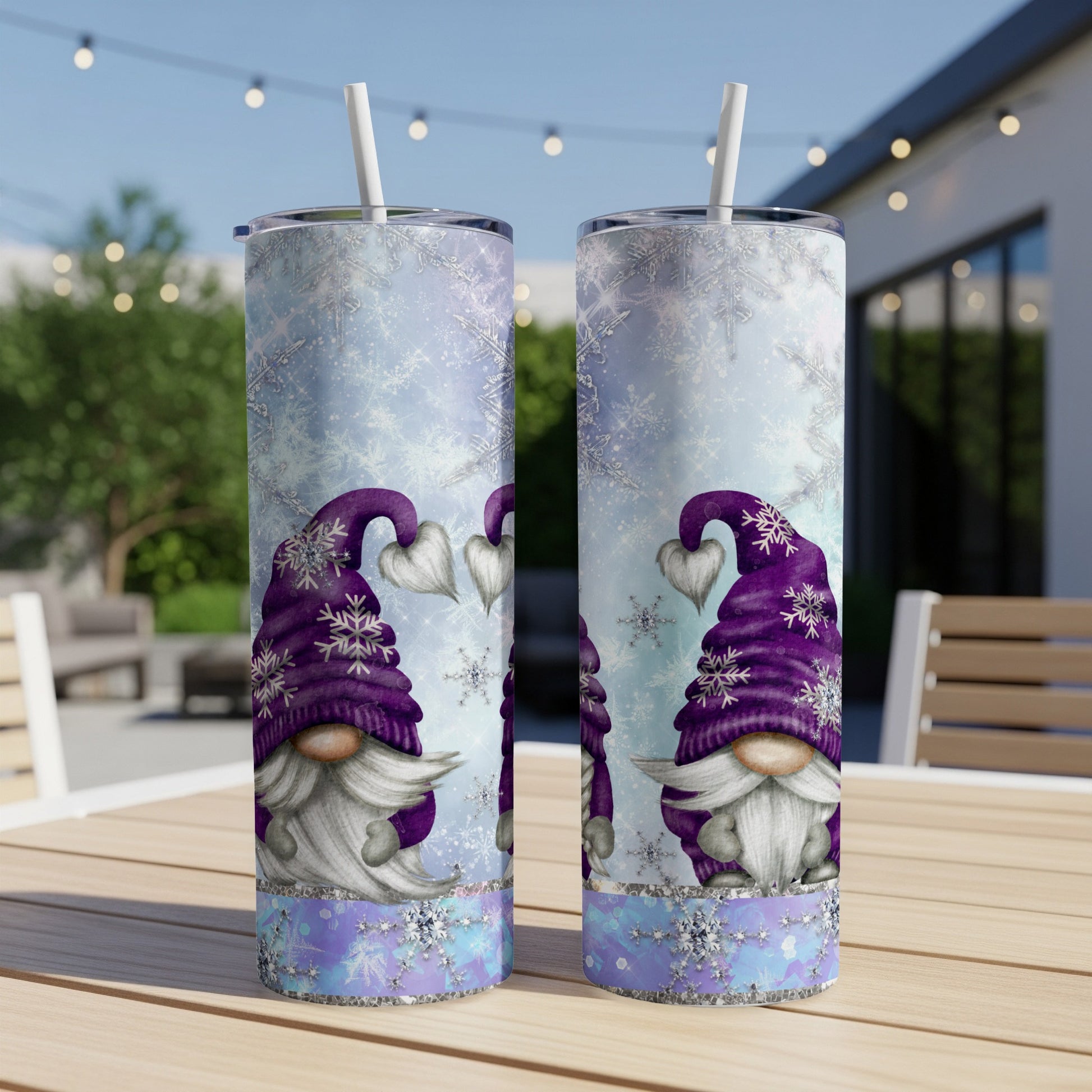 Two tall tumblers with purple gnomes and snowflakes on outdoor table.
